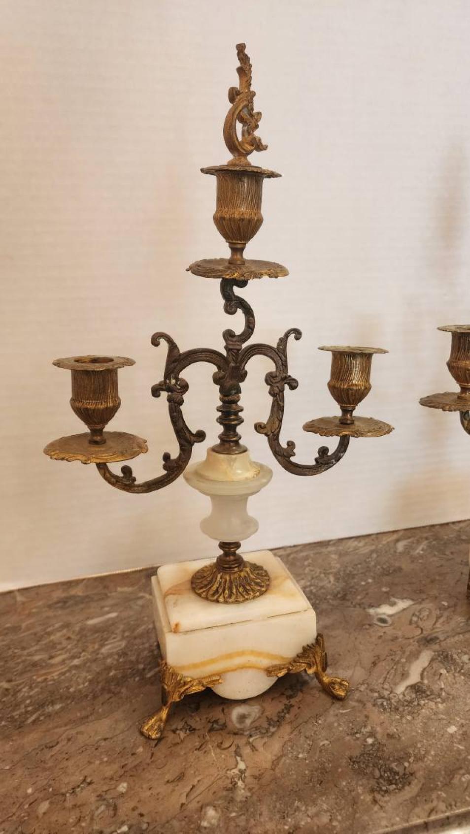 Questa inserzione presenta una coppia di candelabri a tre luci in bronzo dorato, in stile Rococò e molto probabilmente provenienti dalla Francia nel 1900, ciascuno con un terminale centrale staccabile. 

Un candelabro è un portacandele a bracci