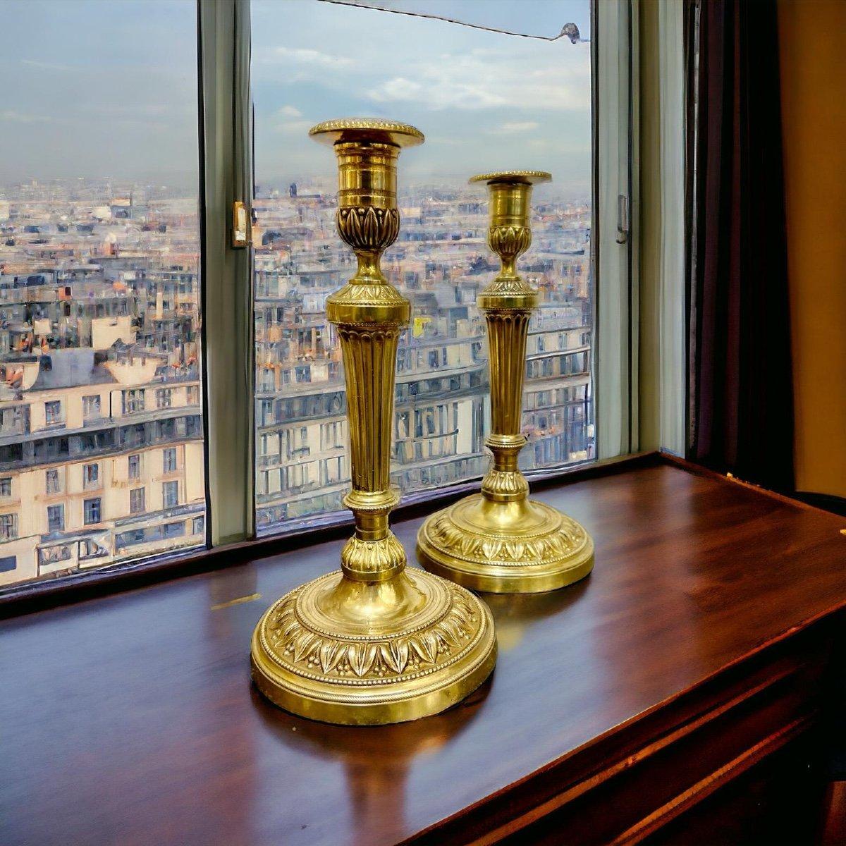 Dieses einzigartige Paar vergoldeter Bronzeleuchter aus dem 19. Jahrhundert aus der Zeit der bourbonischen Restauration in Frankreich (1814 - 1830) zeichnet sich durch ausgefallene Palmettenverzierungen und kannelierte Stiele aus. 

Mit einer Höhe
