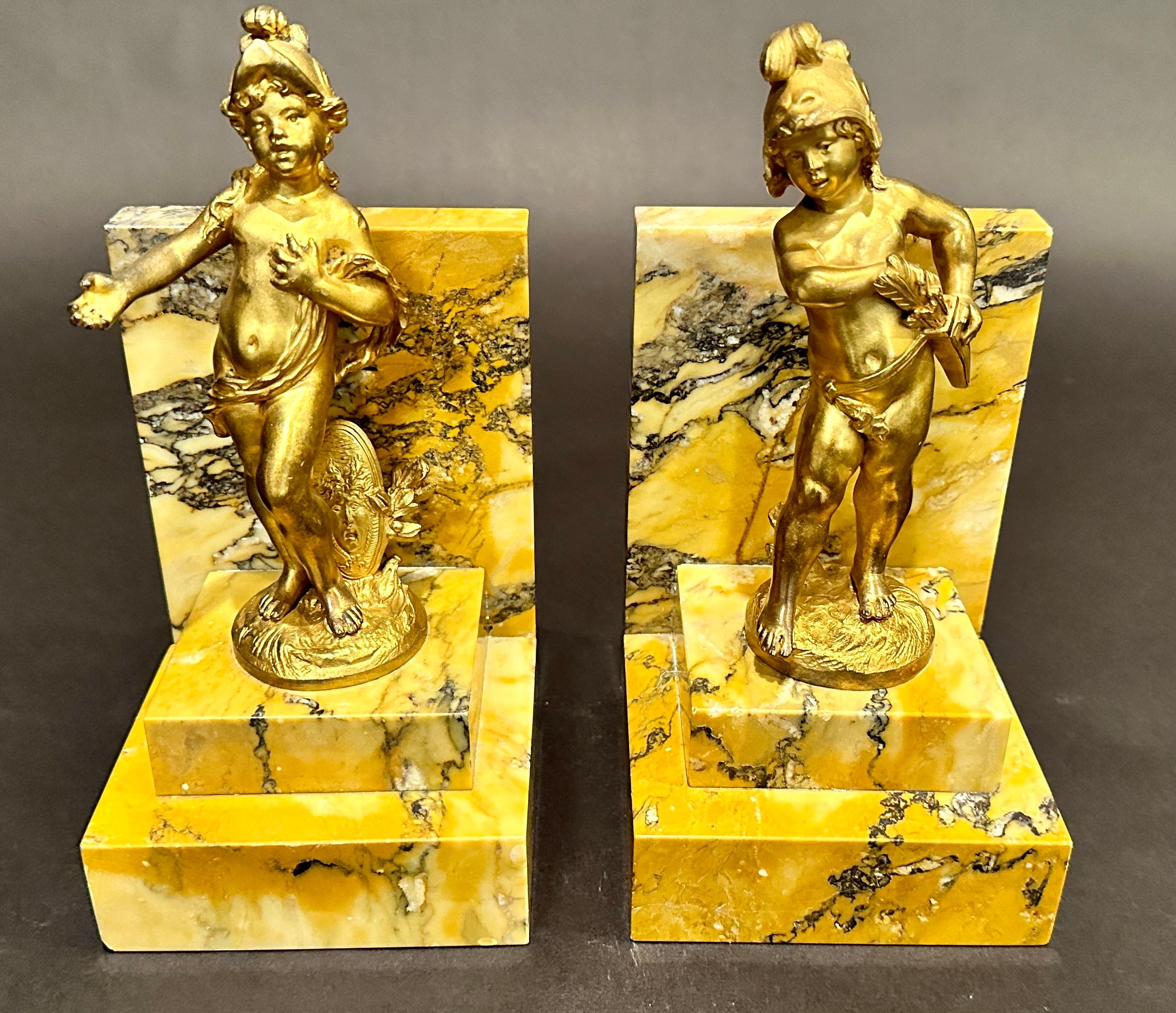 Fine quality pair of figural 19th century gilt bronze bookends by Auguste Moreau. Signed. Young boy and girl depicting warriors, with shield, sword and helmet. Mounted on stepped Italian yellow marble.
