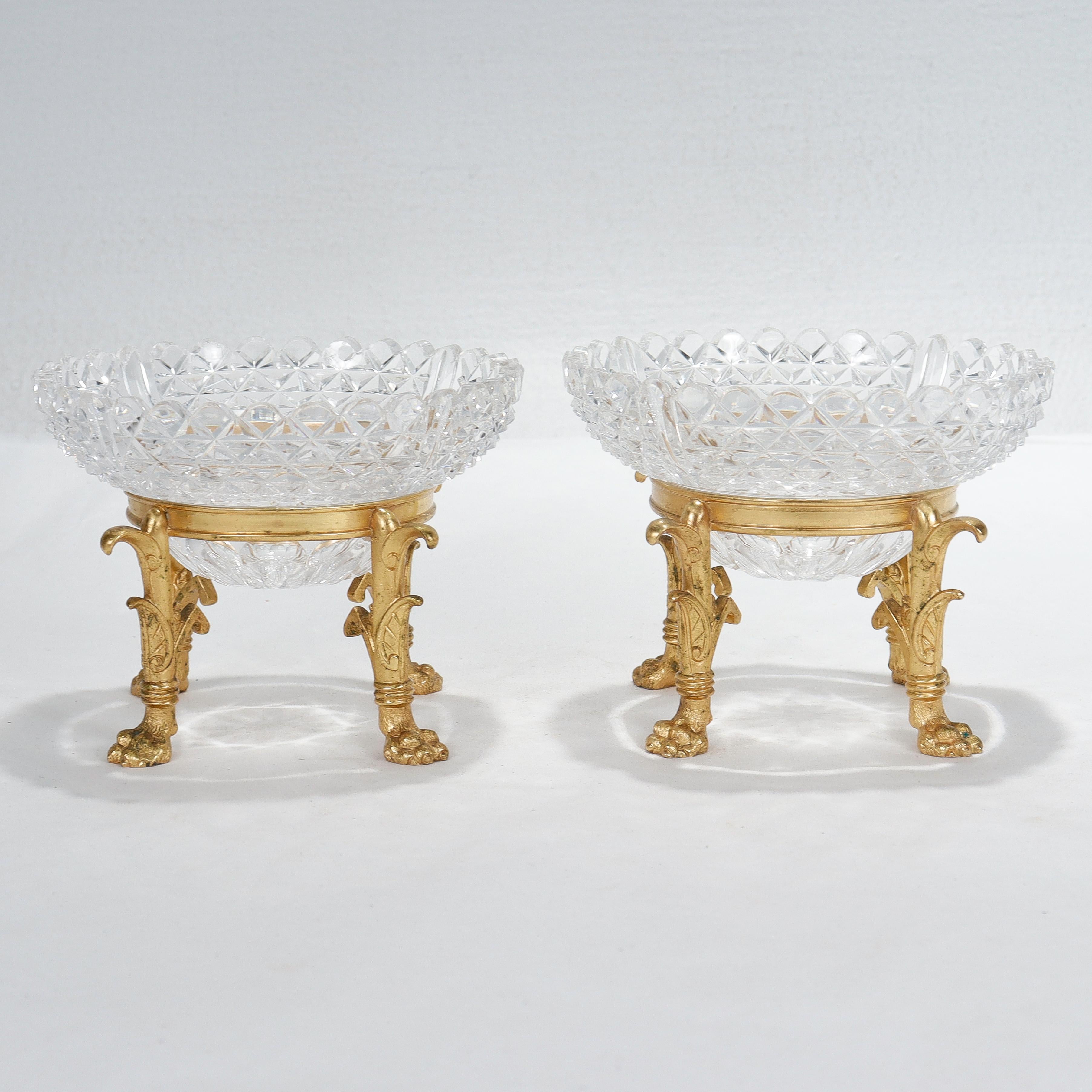 A fine pair of small scale footed bowls. 

In gilt (vermeil) bronze and cut glass.

Attributed to F. & C. Osler.

With Egyptian Revival style hairy paw feet and removable cut glass bowls that rest in a ring supported by four legs.

Simply a