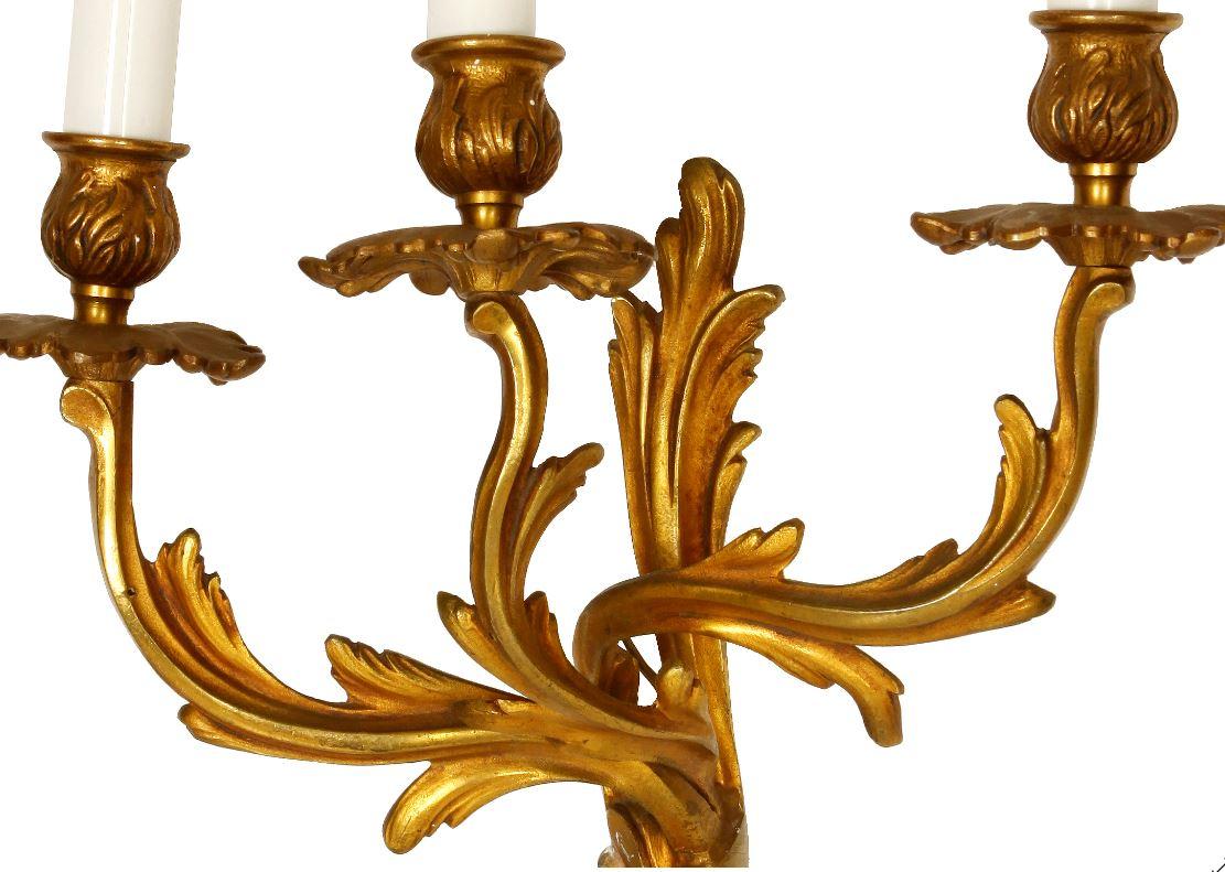 Paar dreiarmige Empire-Wandleuchter aus vergoldeter Bronze mit Blattdetail.