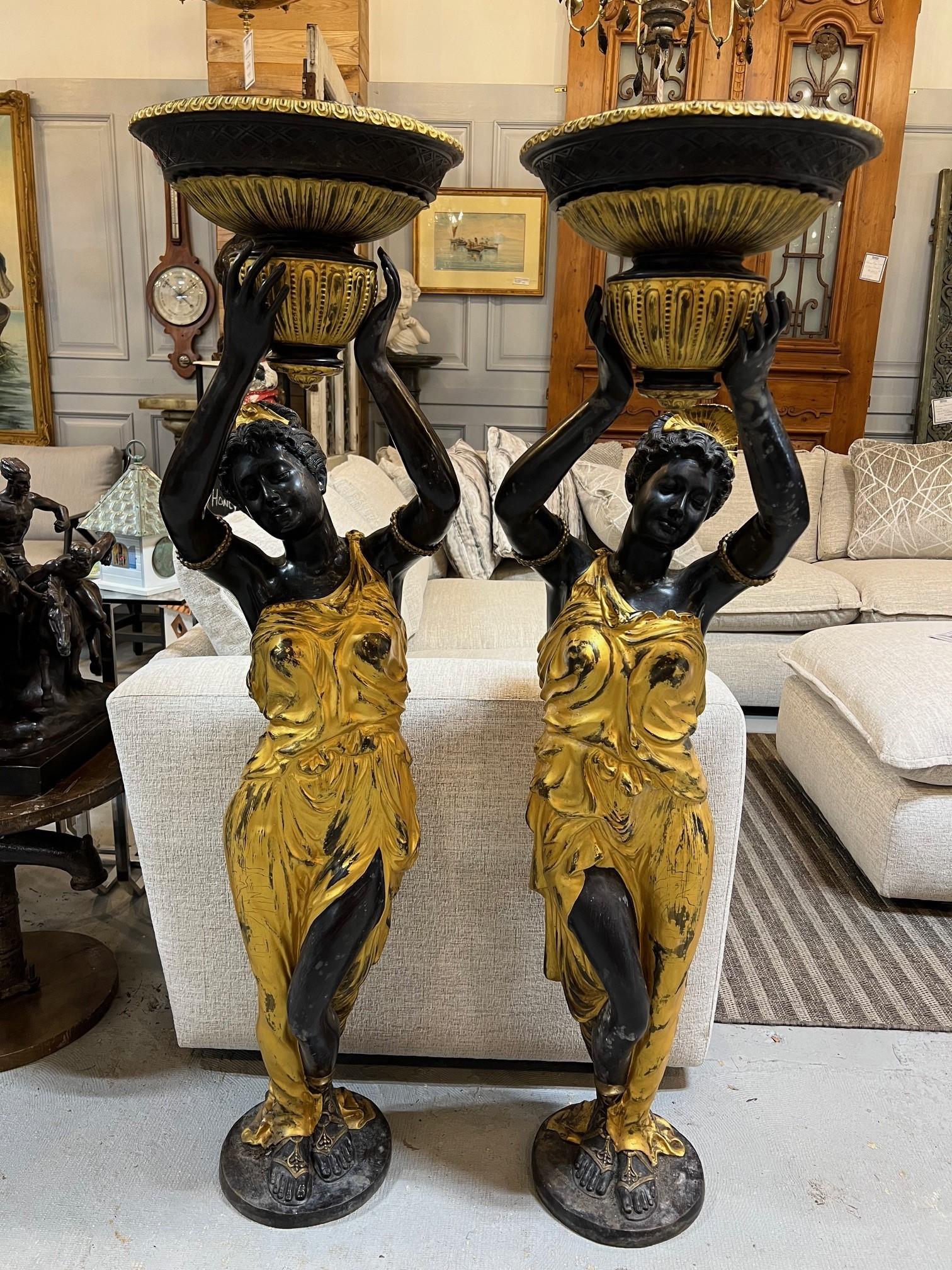 This is a beautiful pair of large gilt bronze female statue jardiniers. A pair of elegant female statues with gilt bronze gowns holding a planter above their head. The planter is 11