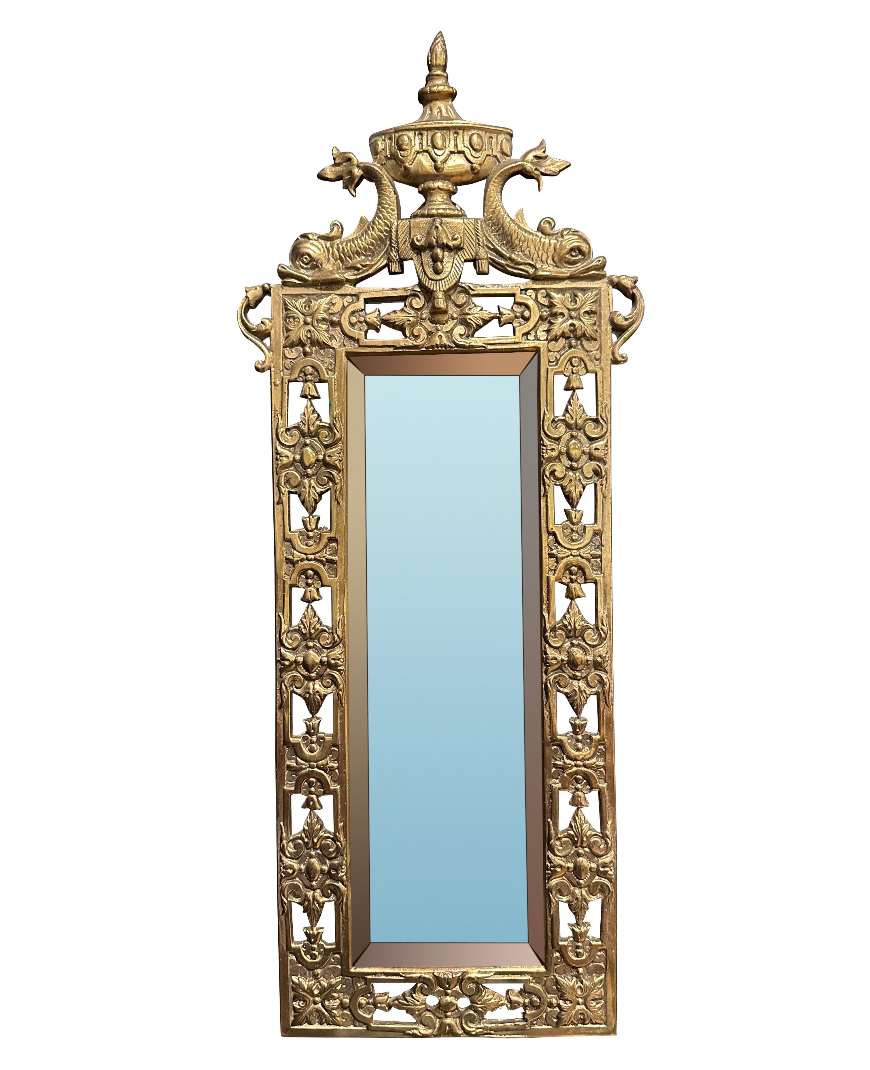 Pair of 19th century petite gilt bronze mirrors. In the Louis XVI style with dolphin fish supporting central urn with flame. Adorned with a border of square rosettes, egg and dart decorations. Original beveled mirrors.