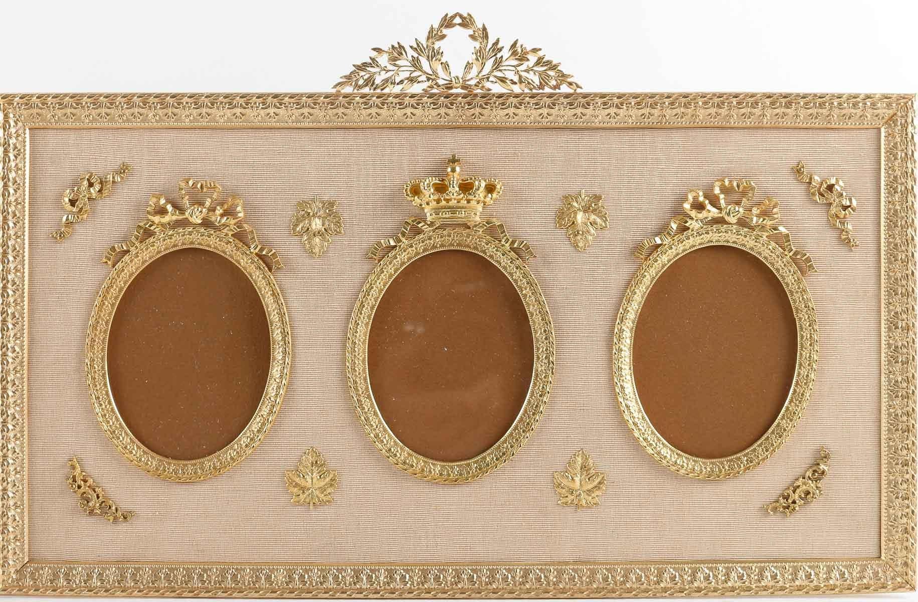Pair of gilt bronze frames for 3 portraits, 19th Century.

Pair of frames with a crown on the central photo in gilt bronze and beige fabric, Napoleon III period, 19th century.
H: 24cm, W: 39cm, D: 2cm
Photo size: w: 3.5cm, h: 7cm
