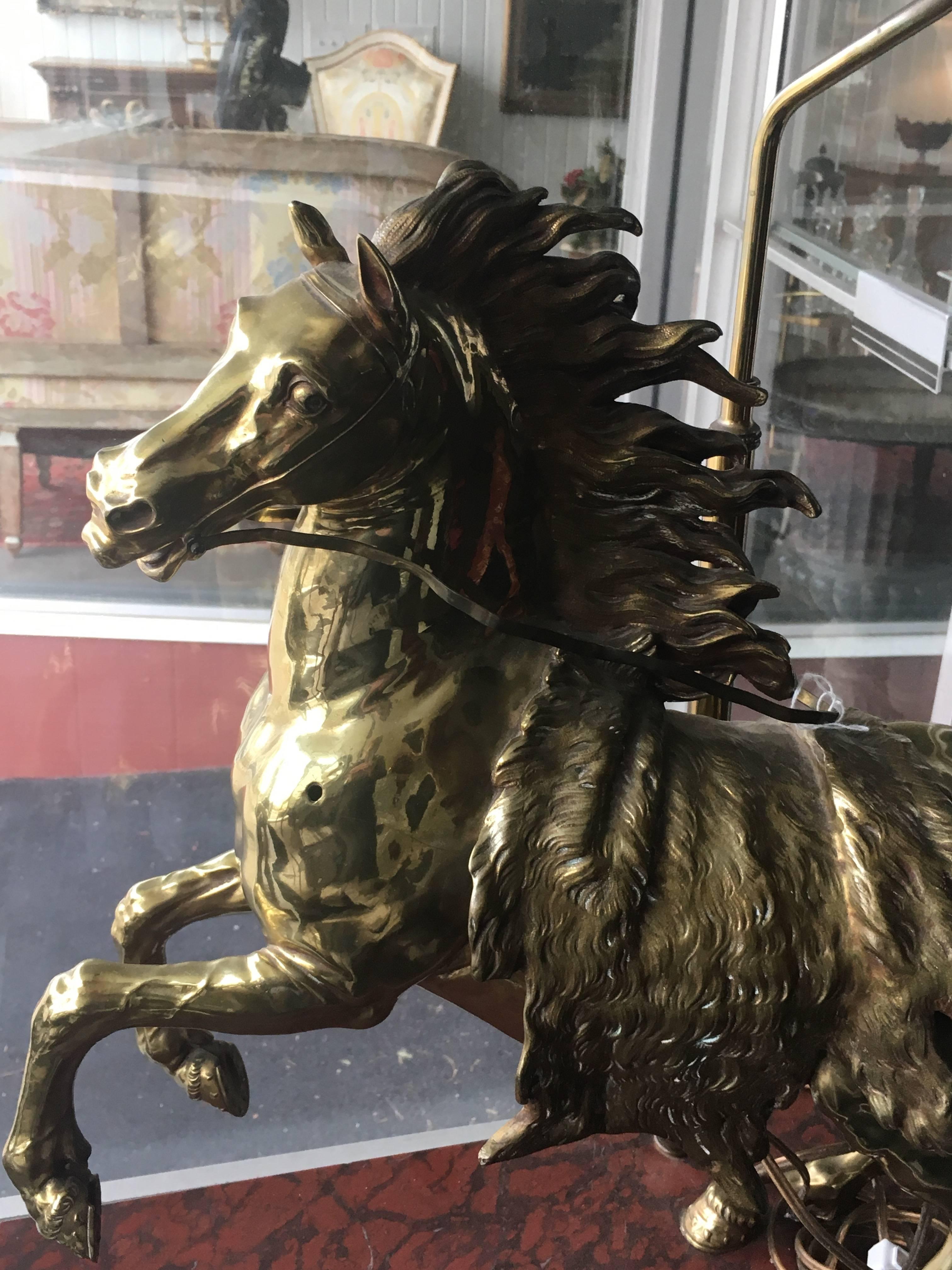 Une paire de chevaux en bronze doré
chacune en forme de cheval au galop, posée sur un socle rectangulaire en faux marbre aux angles arrondis et montée en lampe.
Mesures : Hauteur totale 28 pouces.