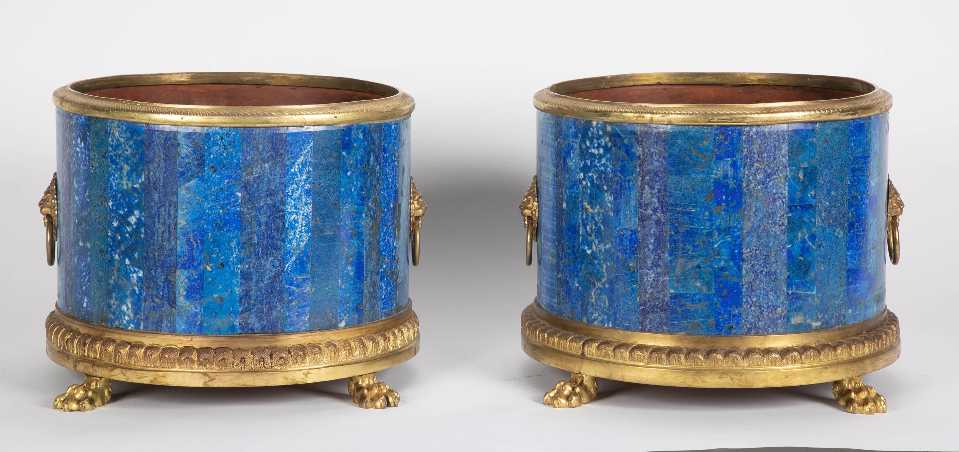 A pair of French gilt bronze Lapis Lazuli planters raised on lions paw feet having lion face handles.



           