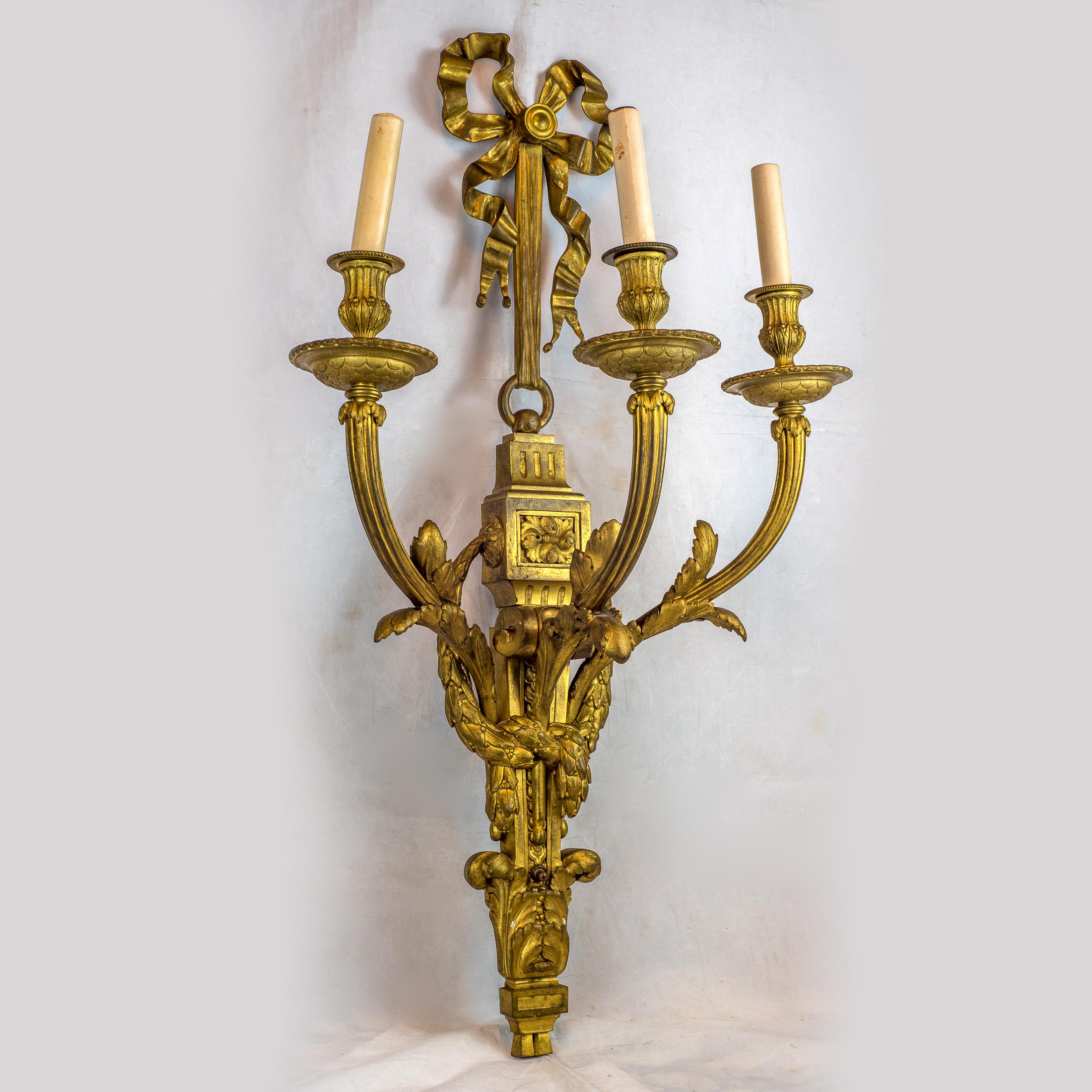 A Fine pair of gilt bronze Louis XVI style three-light wall light sconces
Origin: French
Date: Late 19th century
Dimension: (H) 31 1/4 in. x (W)17 1/2 in. x (D)10 1/2 in.
