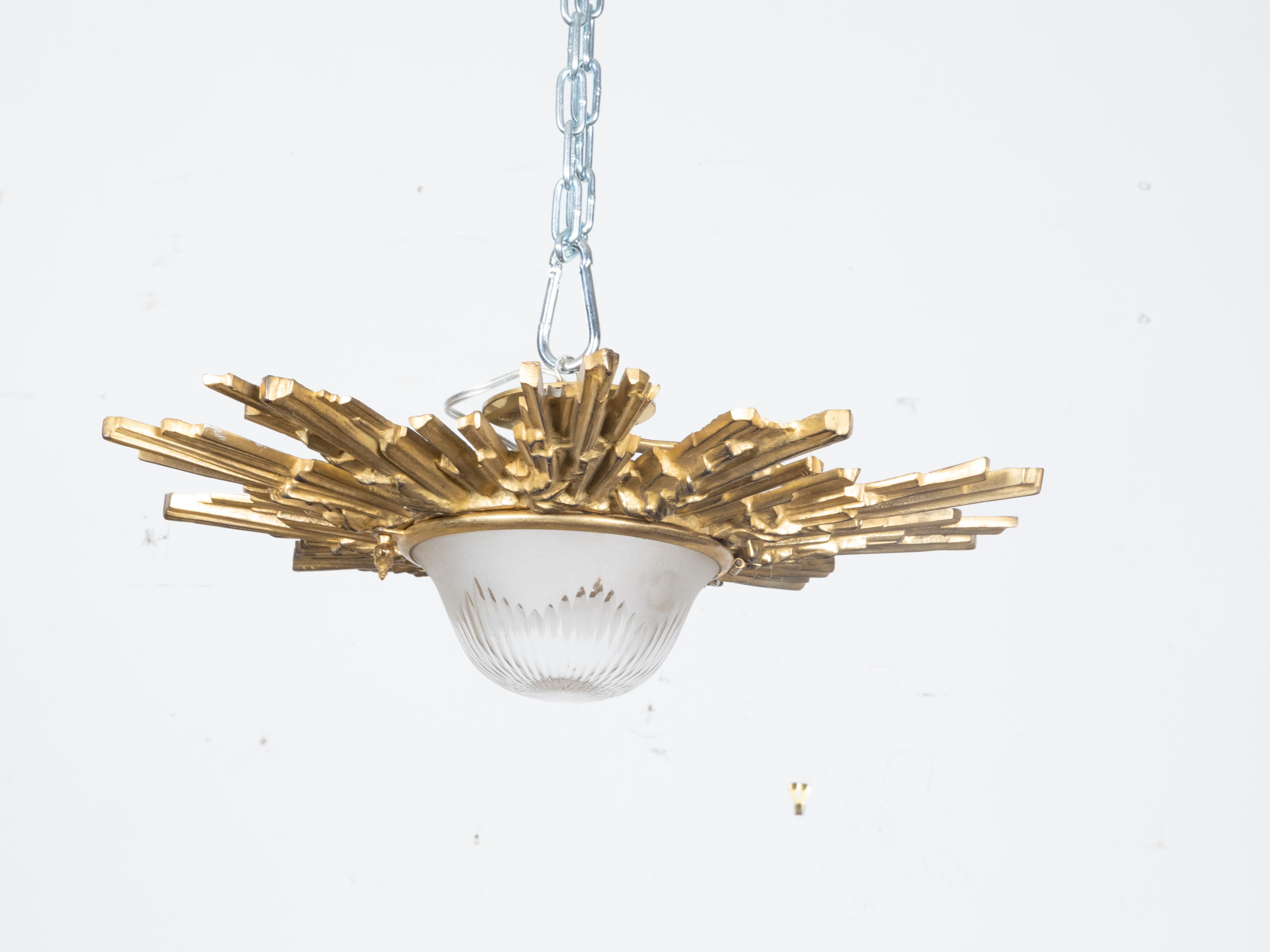 A pair of Midcentury gilt bronze sunburst semi-flush light fixtures with frosted glass bottom concealing the light sockets. Embrace the celestial grandeur with this pair of Midcentury gilt bronze sunburst semi-flush light fixtures. Skillfully
