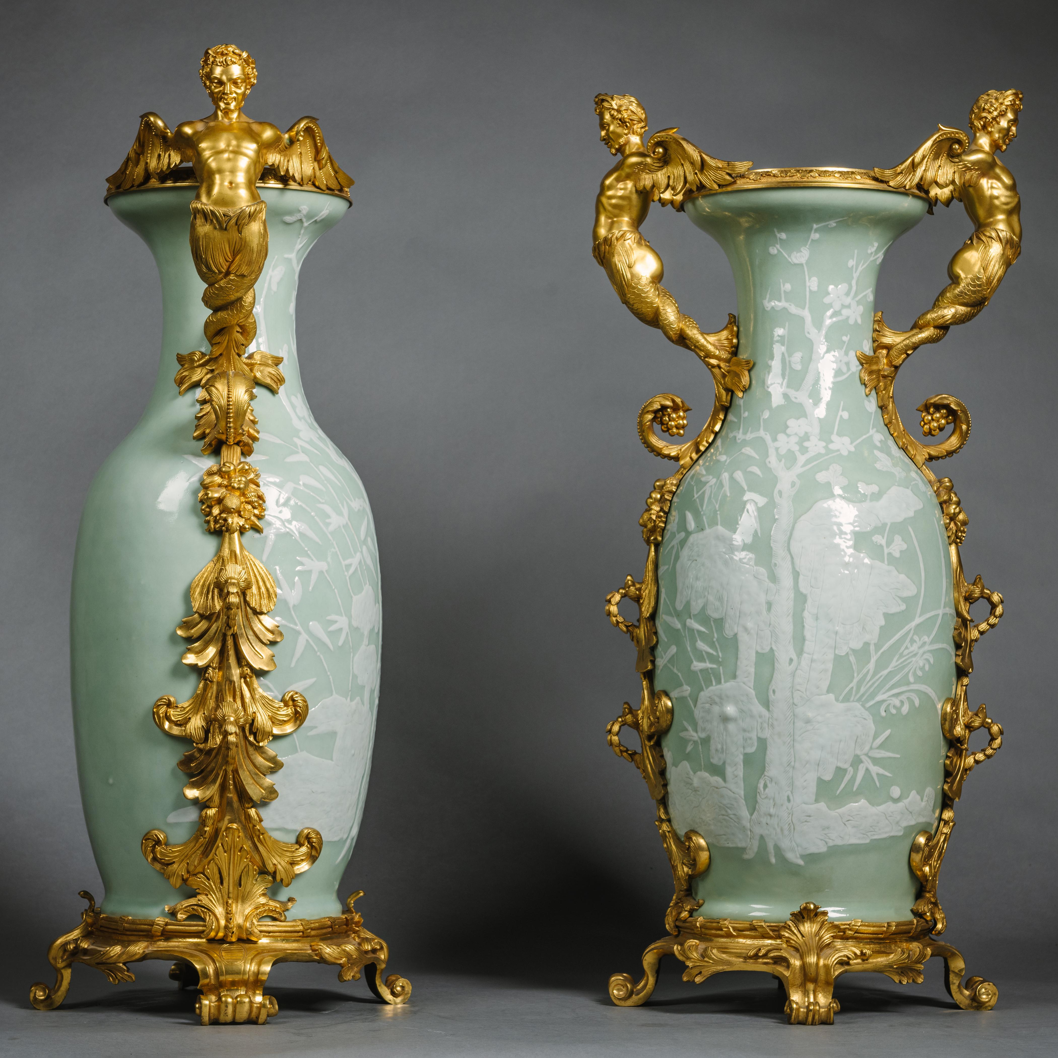 A Pair of Large Gilt-Bronze Mounted Chinese Celadon-Ground and Slip Decorated Porcelain Vases.

These vases of Chinese celadon porcelain from the late Quing Dynasty are slip-decorated with willow trees and prunus flowers. The finely sculpted