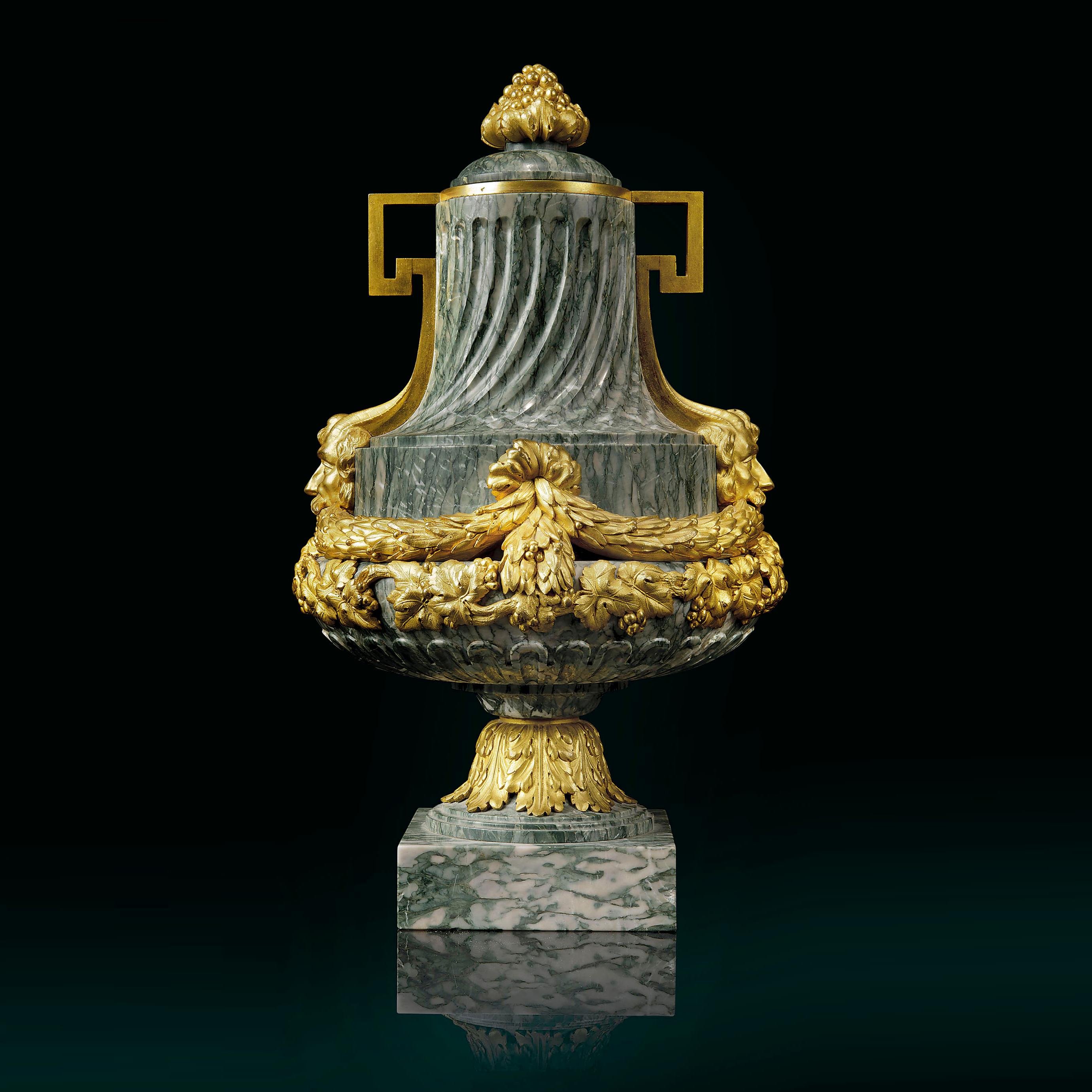 A very fine pair of gilt-bronze mounted green cipollino marble vases.

Each vase is of baluster form the marble body encircled by laurel and vine leaf mounts, beneath a spirally fluted neck, loop handles and mask terminals, a pomegranate finial