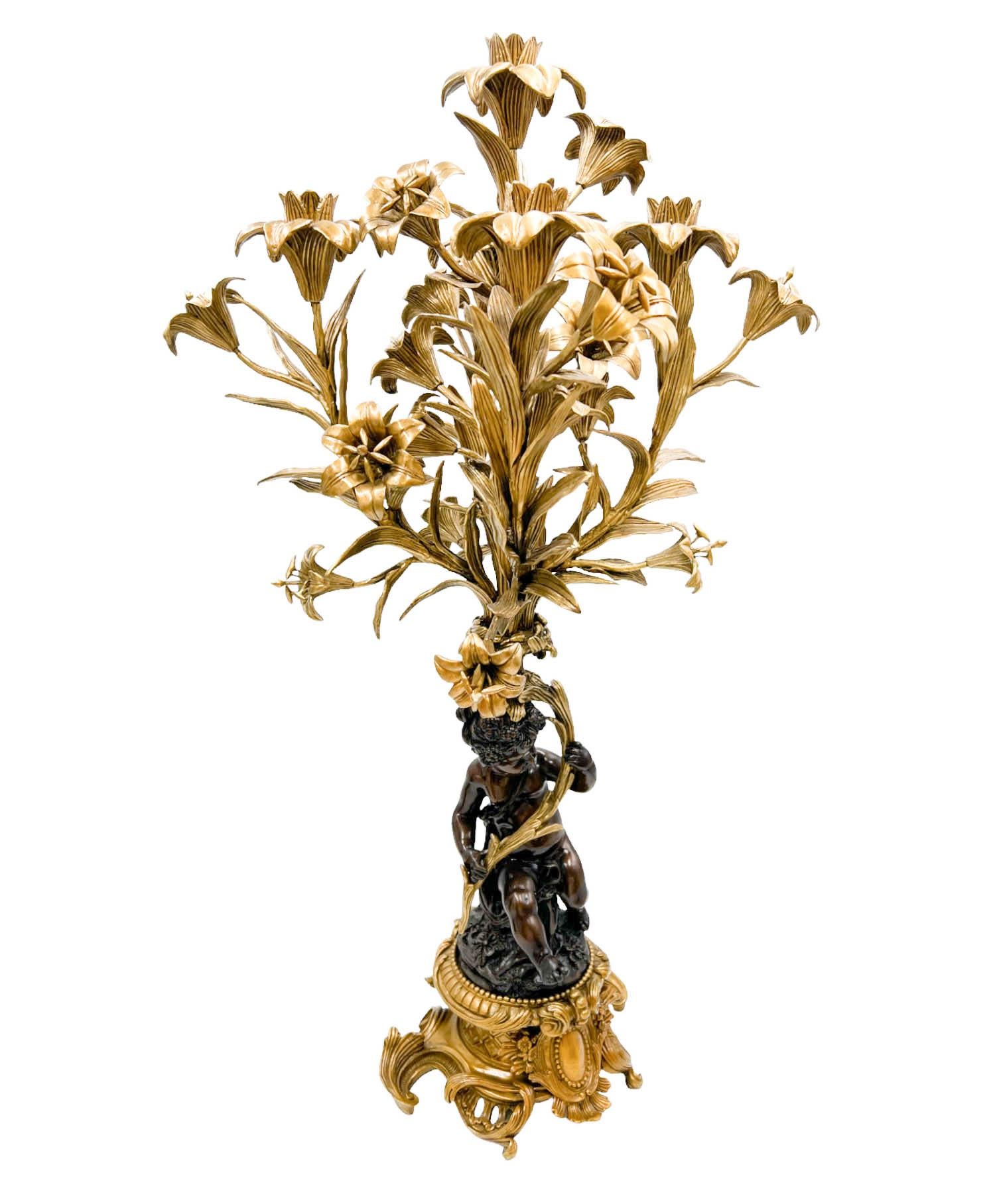A very rare pair of Gilt Bronze Mounted Putto 5-Arm Candelabra by United Wilson.  The pair reflects the aesthetics of the Rococo period, characterized by neoclassical influences, ornate detailing, and elegant design elements.  Each candelabra 