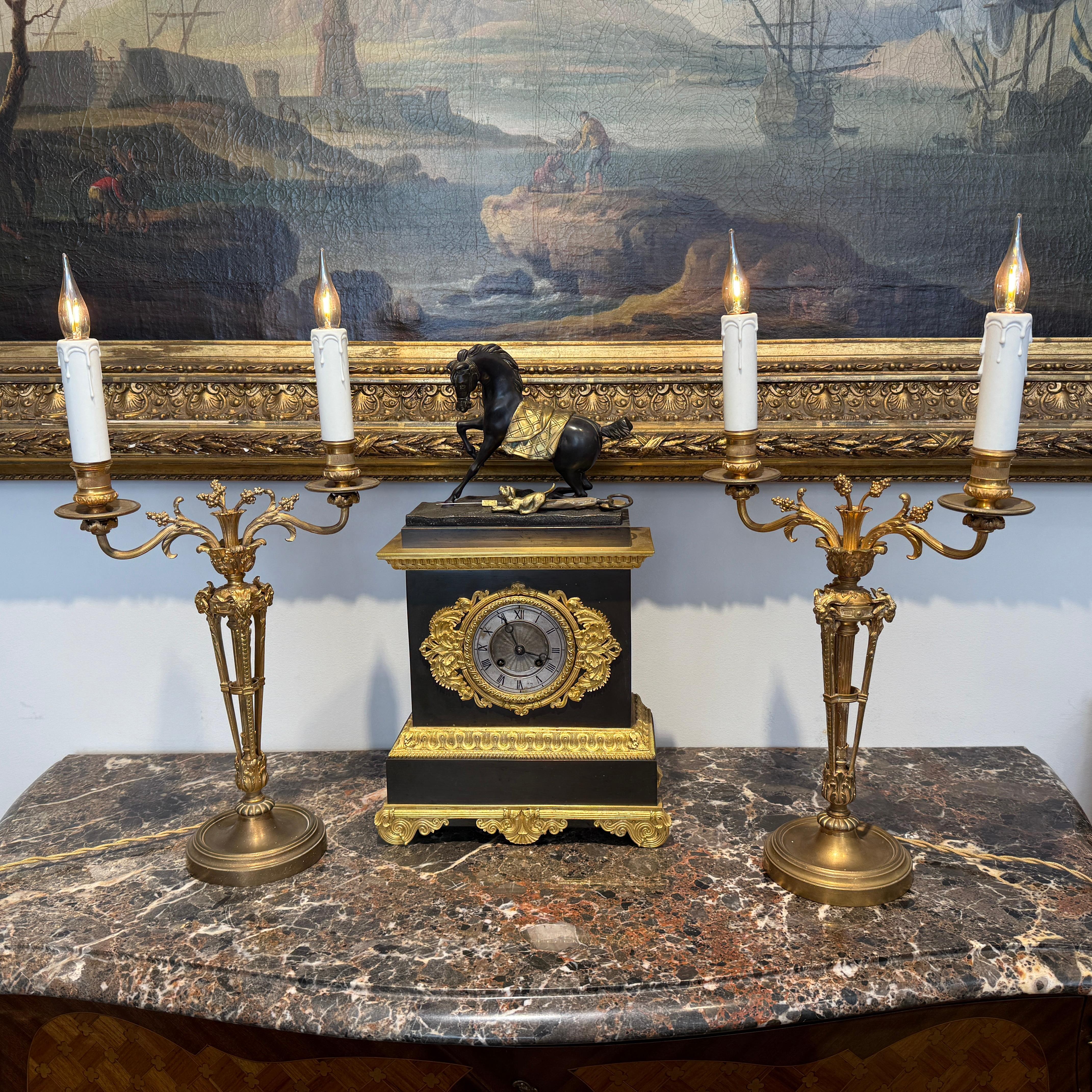 A pair of gilt bronze candelabra lamps, elegantly transformed into electric lighting while preserving their timeless grandeur. Each piece is masterfully crafted with intricate neoclassical detailing, featuring gracefully scrolled arms, delicate