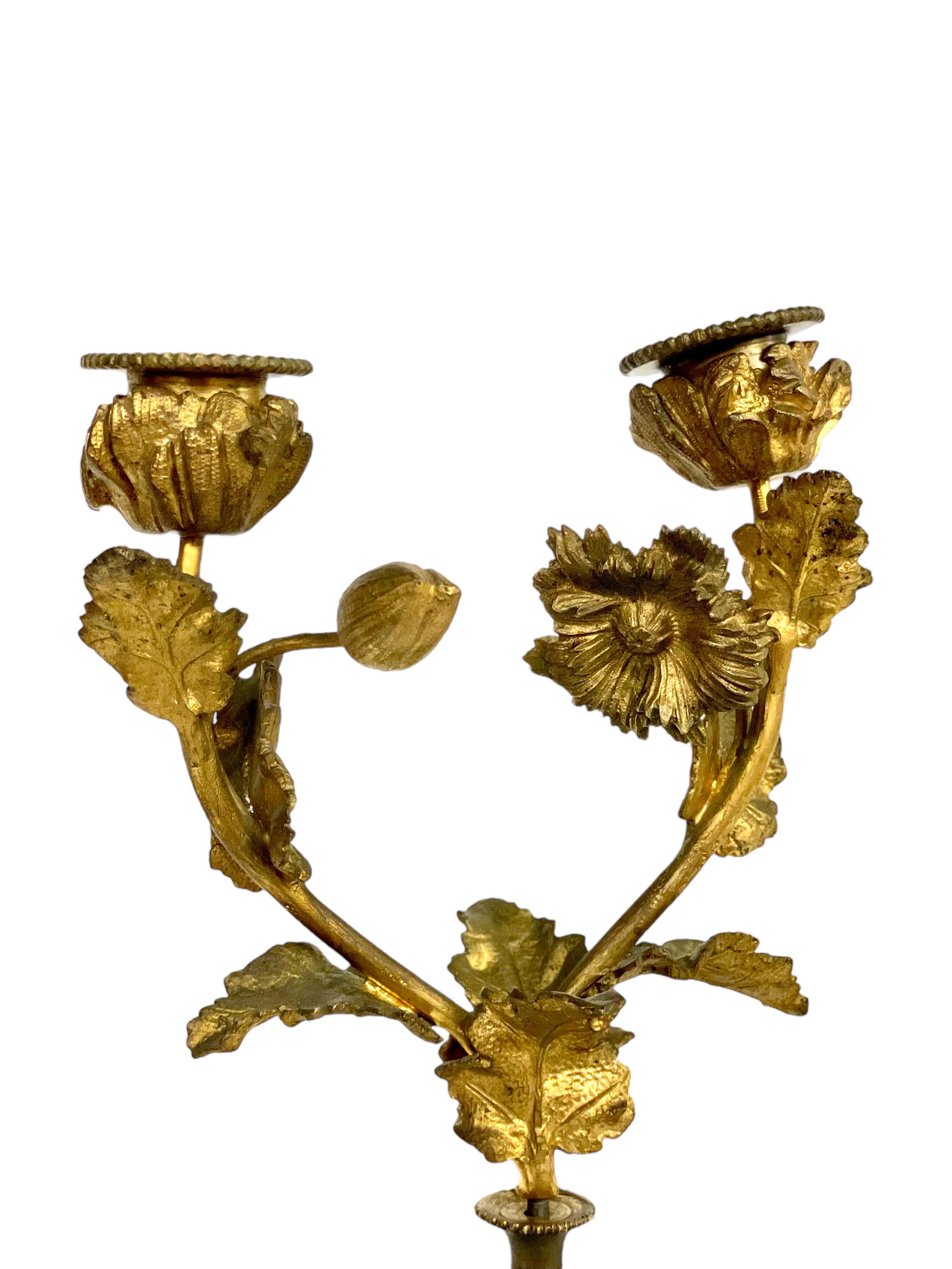 An absolutely stunning pair of late 19th century Louis XVI style two-light candelabras in Sèvres- style porcelain and gilt bronze ormolu. These magnificent candle holders feature pear-shaped porcelain lower sections, hand painted with polychrome