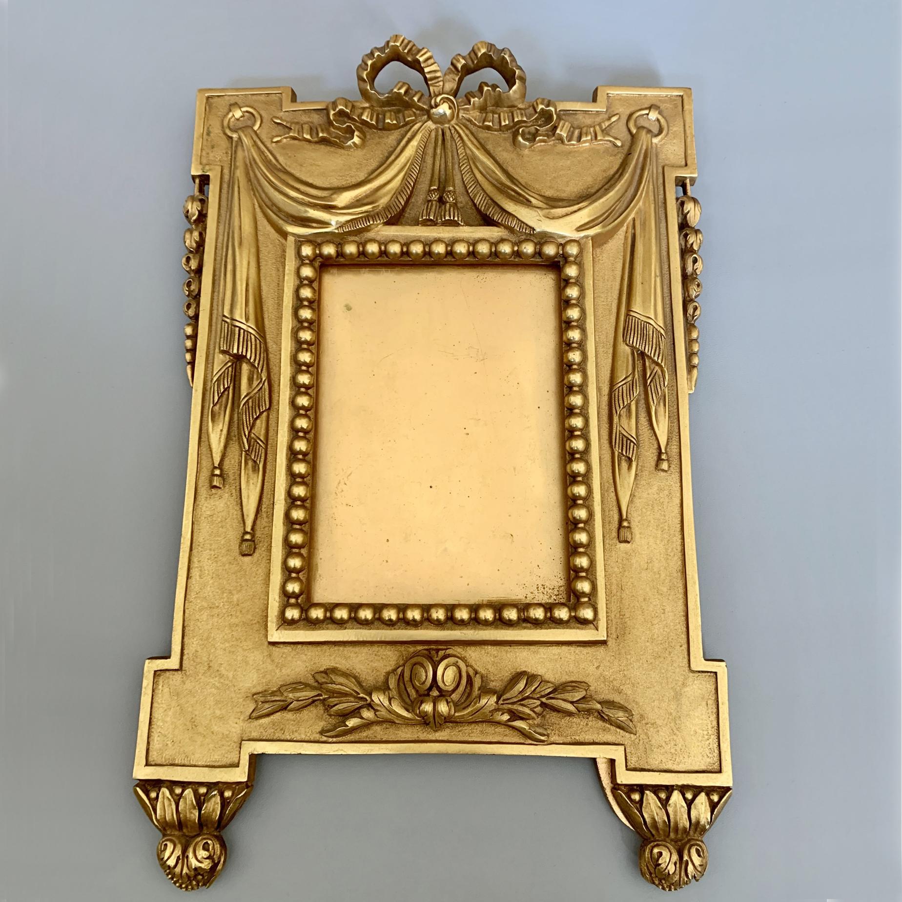 Pair of gilt bronze picture frames, Napoleon III period, French, circa 1875. The frames are decorated with draped curtains opening up to reveal and adorn the valuable picture. The ormolu frames were actually made for portraits as it became very