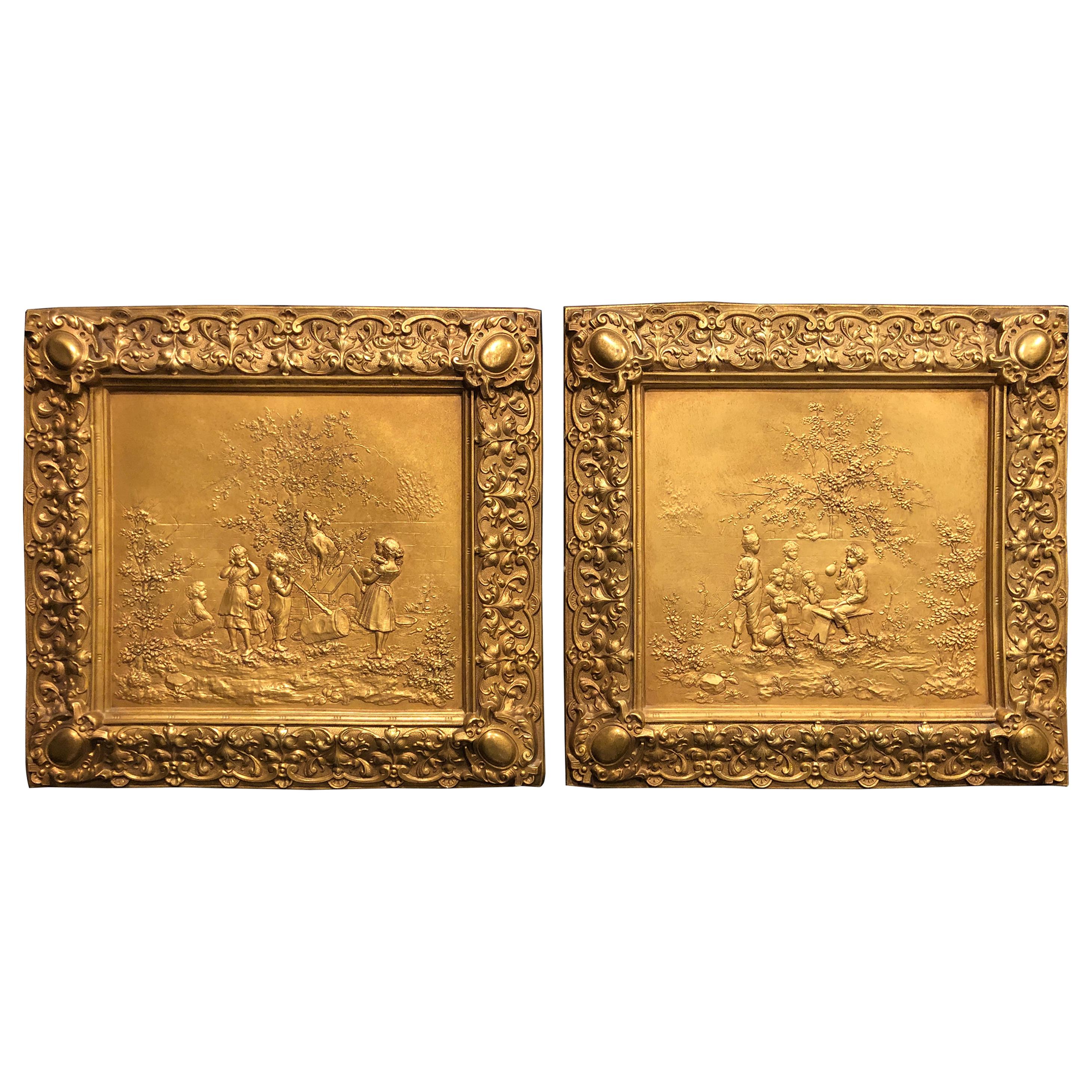 Paire de plaques en bronze doré représentant des enfants