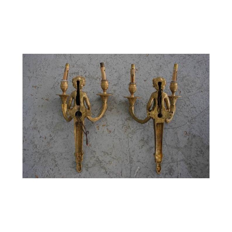 Pair of gilded bronze light wall sconces with babies. French work of the early 19th century. Louis XVI style.