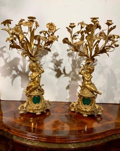 Pair of gilt bronze three lights each with putti, malachite centered at base