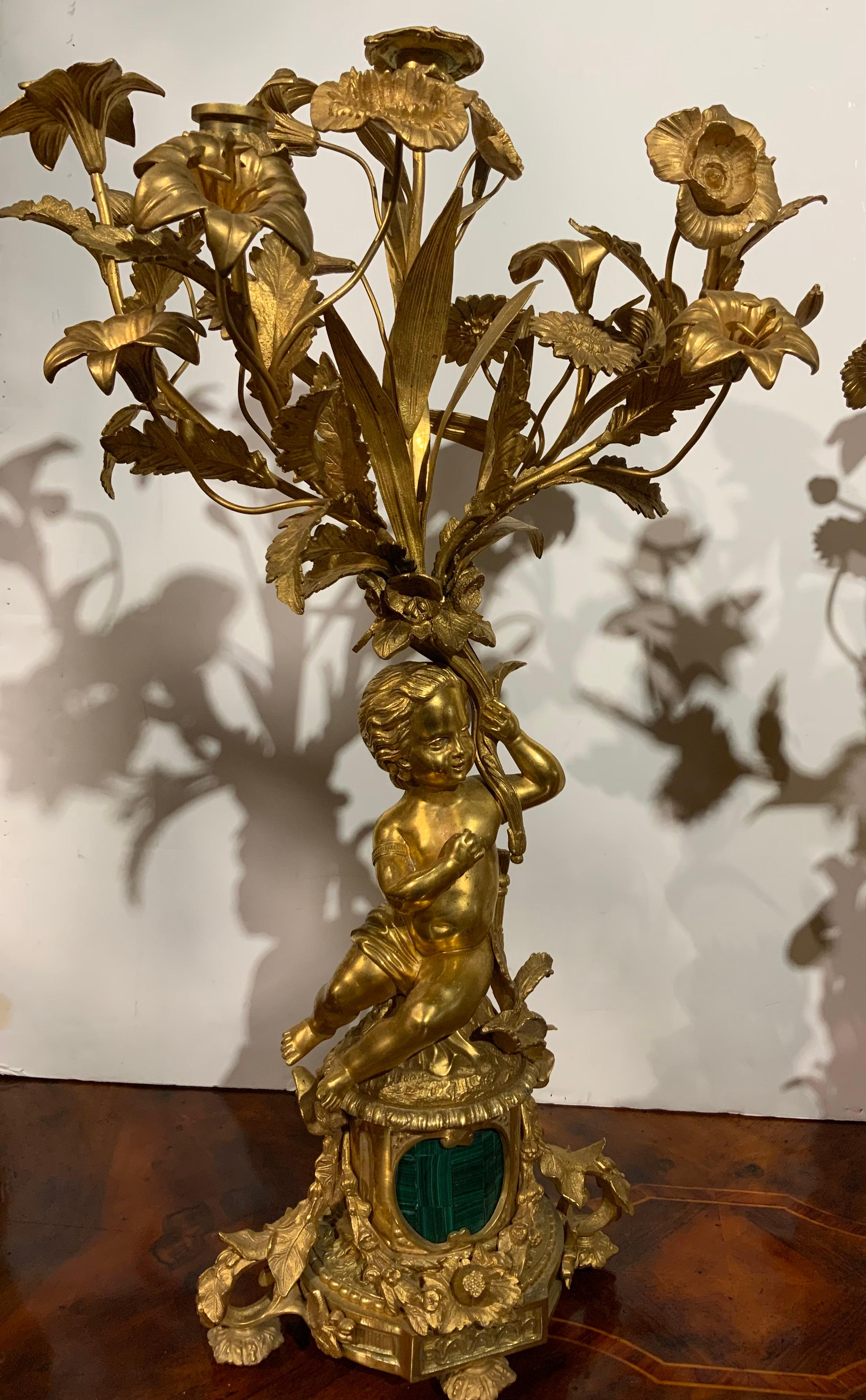 Gilt Pair of gilt bronze three lights each with putti, malachite centered at base For Sale