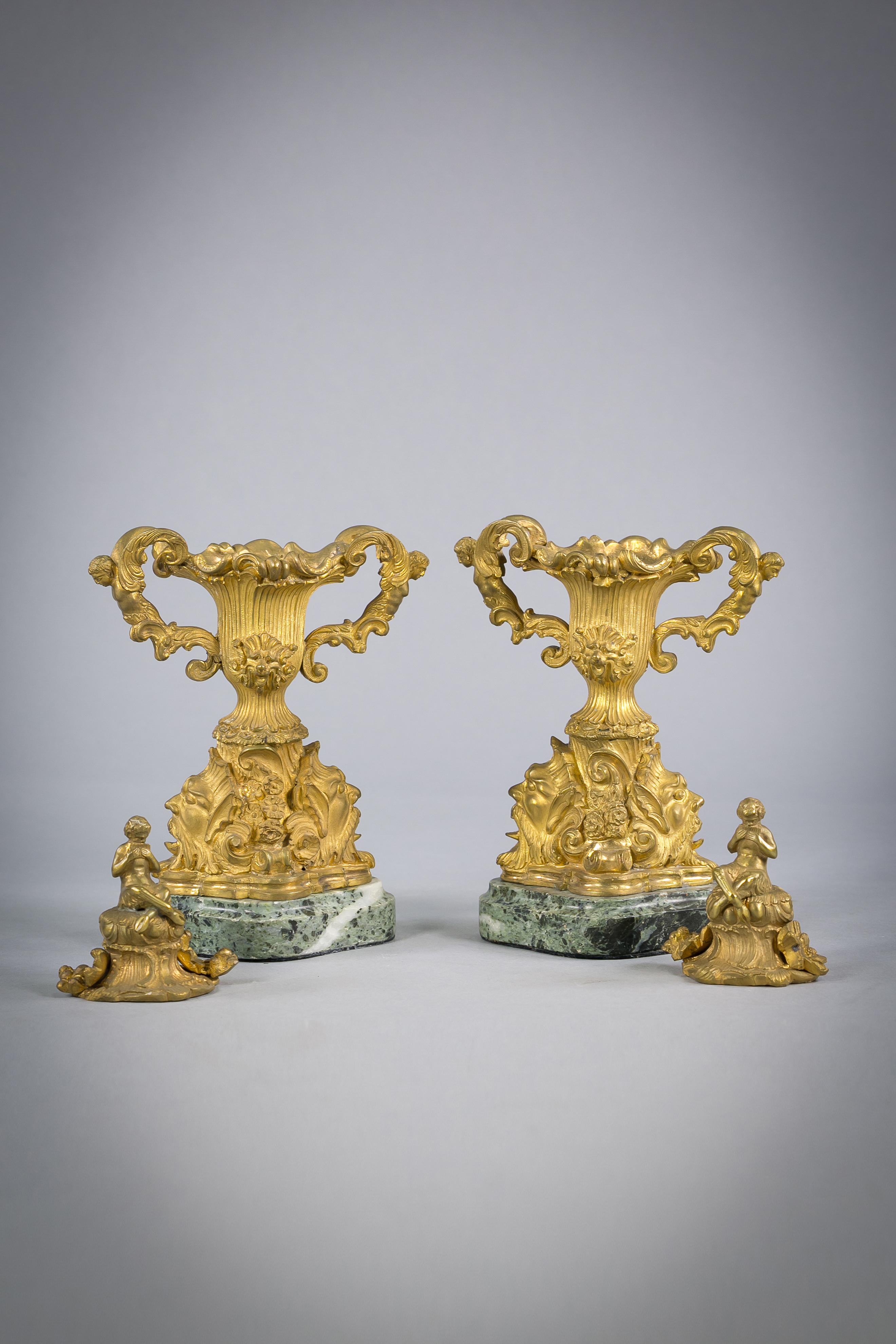 Pair of gilt bronze two handled covered urns on marble bases, French, circa 1890.