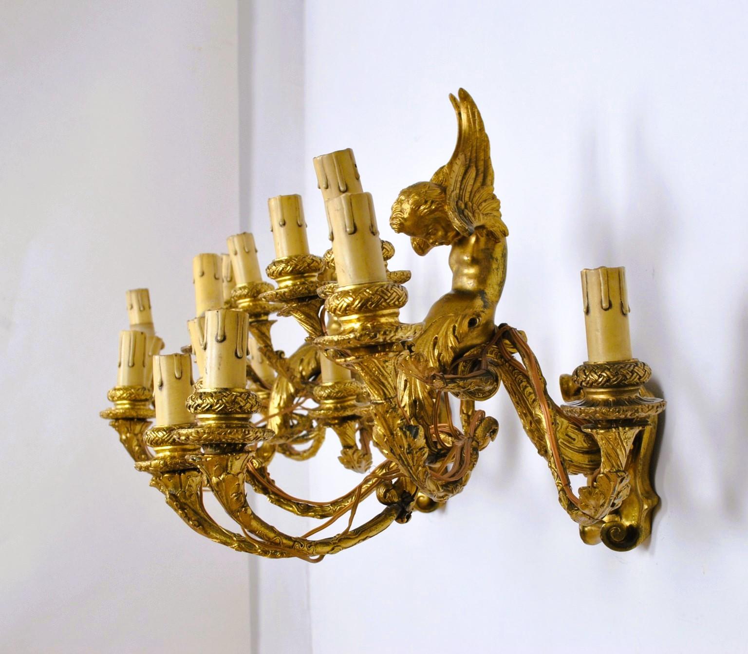 Coppia di applique in bronzo dorato, con 8 bracci luminosi ciascuna: ricca decorazione a foglie sui bracci e sulle prese, puttini alati sulla parte fissata alla parete

Vecchi restauri, un'ala indebolita - elettricità da ricollegare agli standard