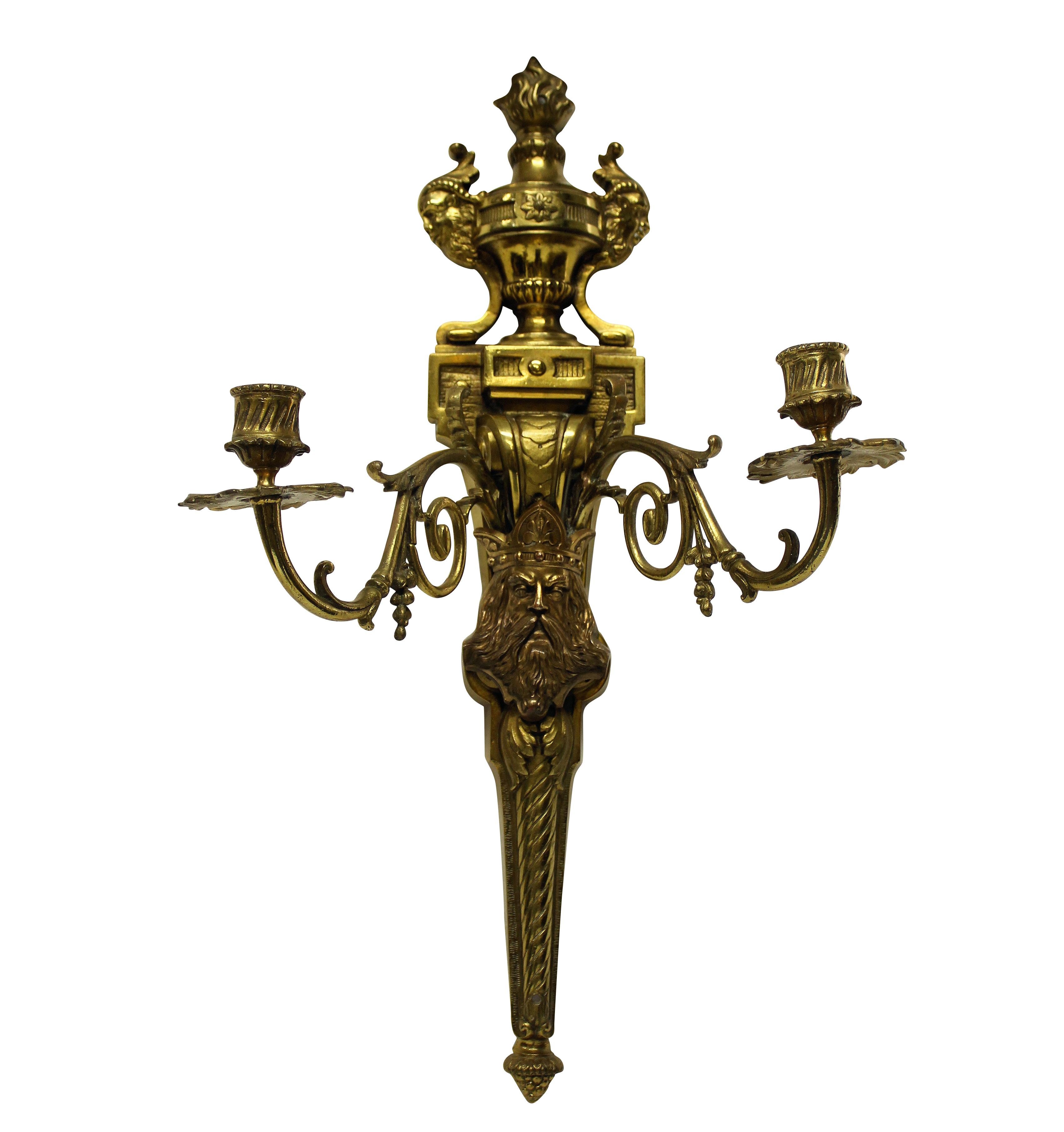 A pair of English, finely burnished Victorian wall sconces in gilt bronze. Depicting in the centre, a crowned King and with mythological motifs.