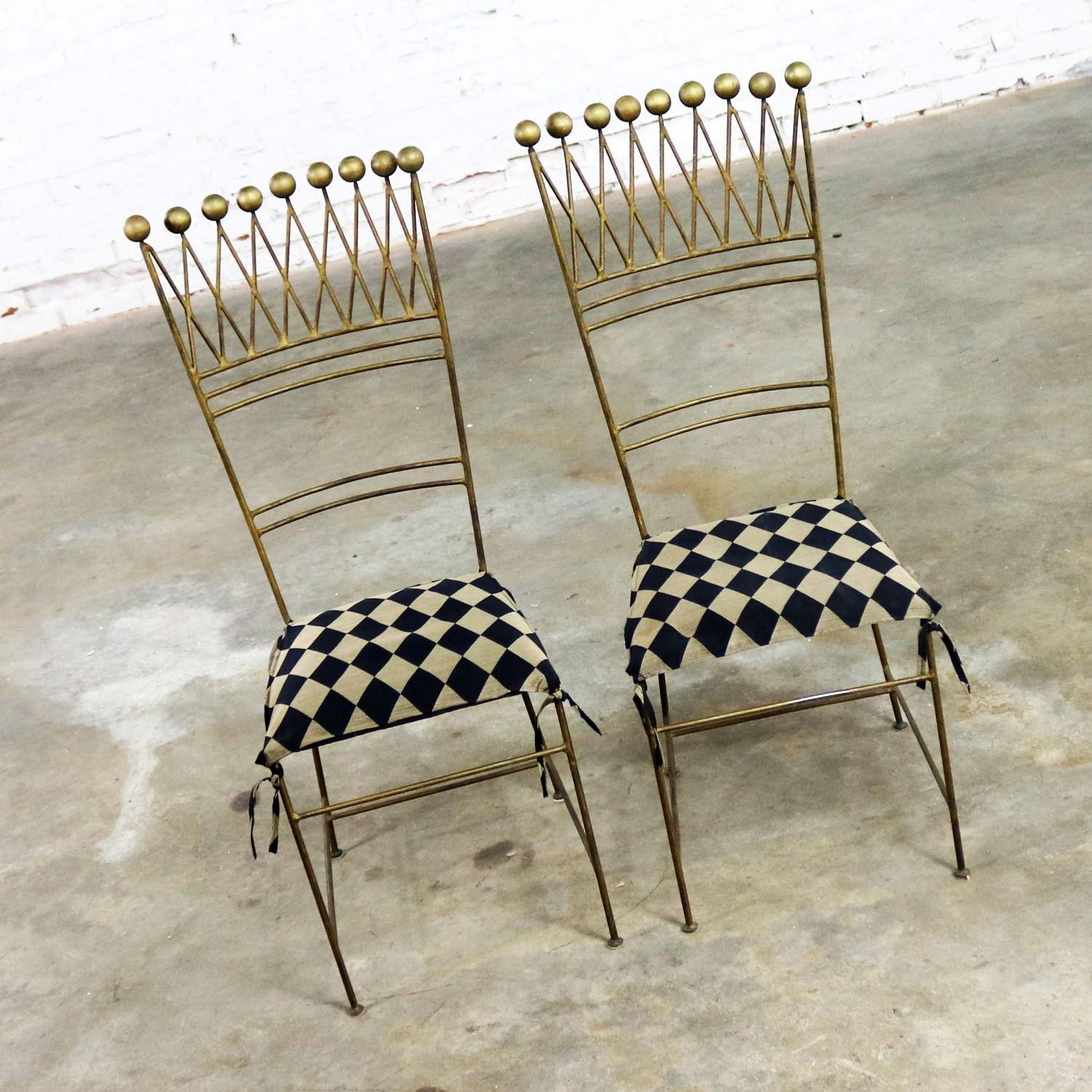 Awesome pair of gilt iron chairs in a harlequin style which look like a jester’s crown with ball finials across its top. We are calling them Art Deco or Hollywood Regency. They are in wonderful ready-to-use vintage condition. The gilded iron has