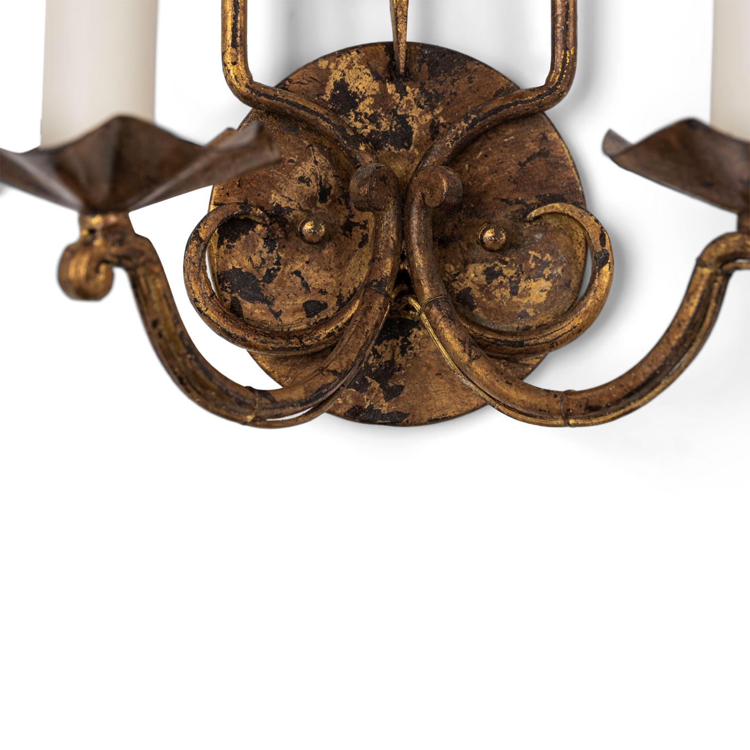 Pair of gilt-iron French sconces, two-arm gilded iron sconces from France, circa 1880-1900. Newly wired for use within the USA using all UL listed parts. Back-plate added for easy wall-installation and finished to match sconces.