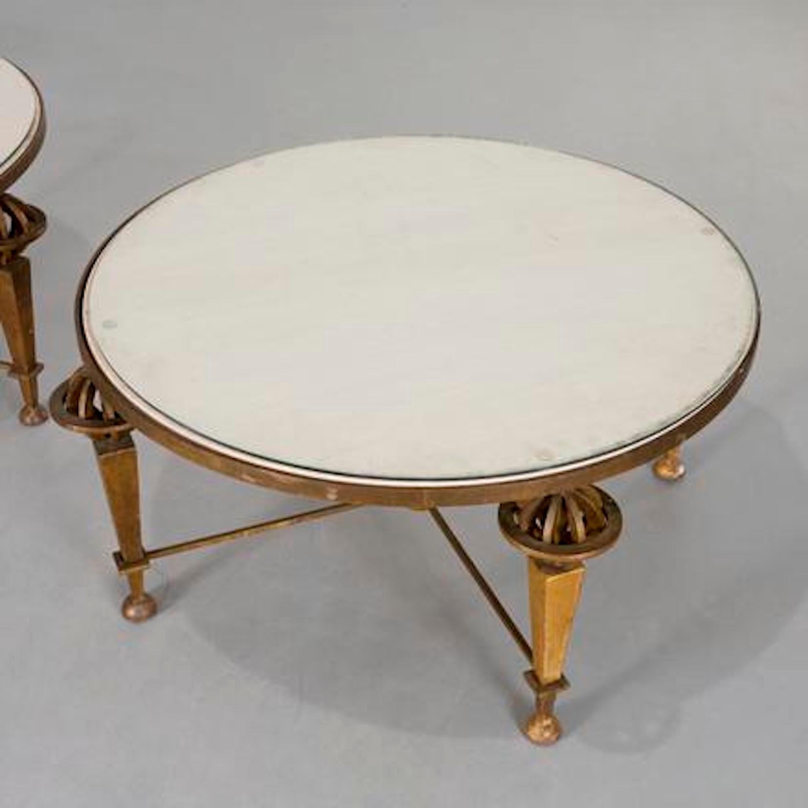 Paar runde vergoldete Eisen-Tische  Gilbert Poillerat zugeschrieben  die  Tischplatten eingelegt mit
Beilage  mit Glas, auf vier Armillargläsern über pyramidenförmigen Beinen stehend
durch eine Bahre, die sich in einer zentralen, auf Kugelfüßen