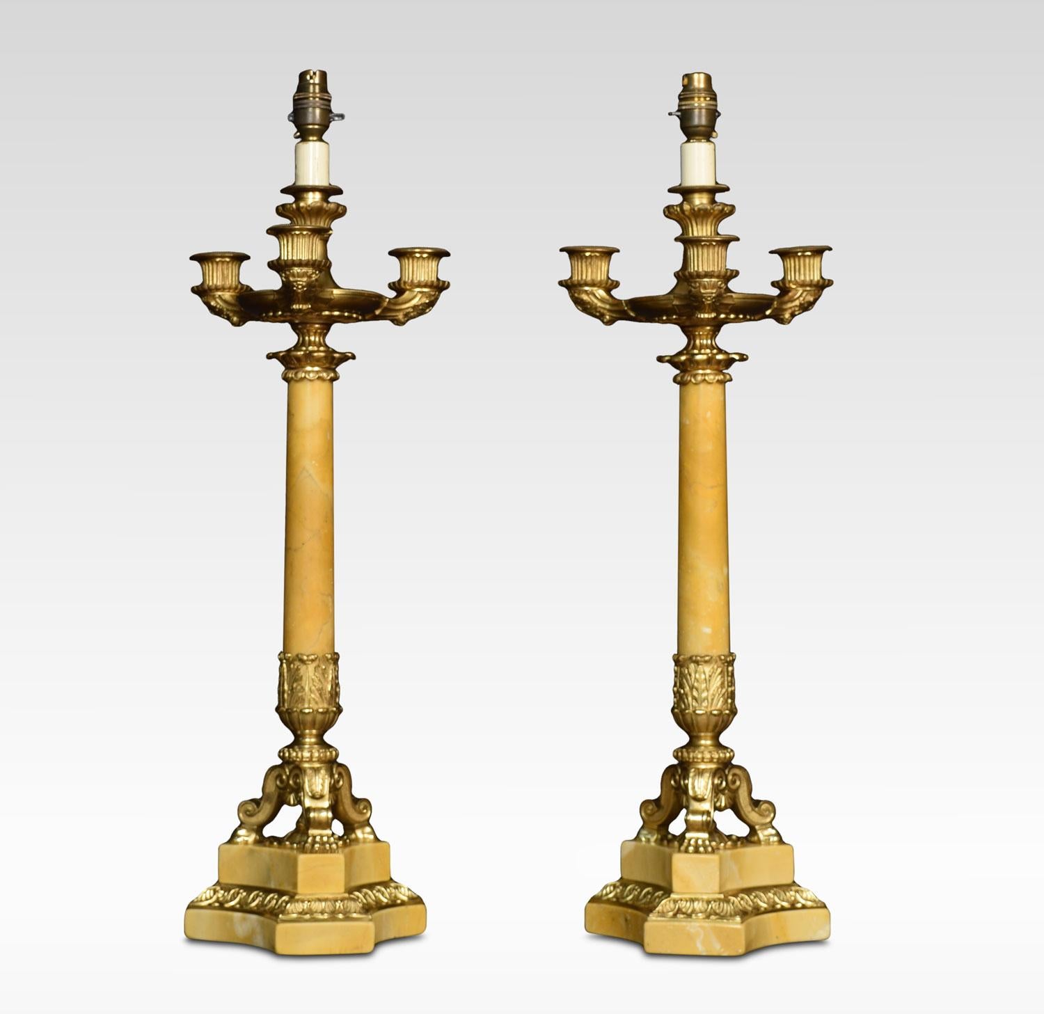 Large pair of Sienna marble and gilt metal lamps, each with a central fluted column surmounted by a lamp supporting three further ornate branches of sconces, all raised upon leaf capped scrolling legs terminating in stepped bases. Together with