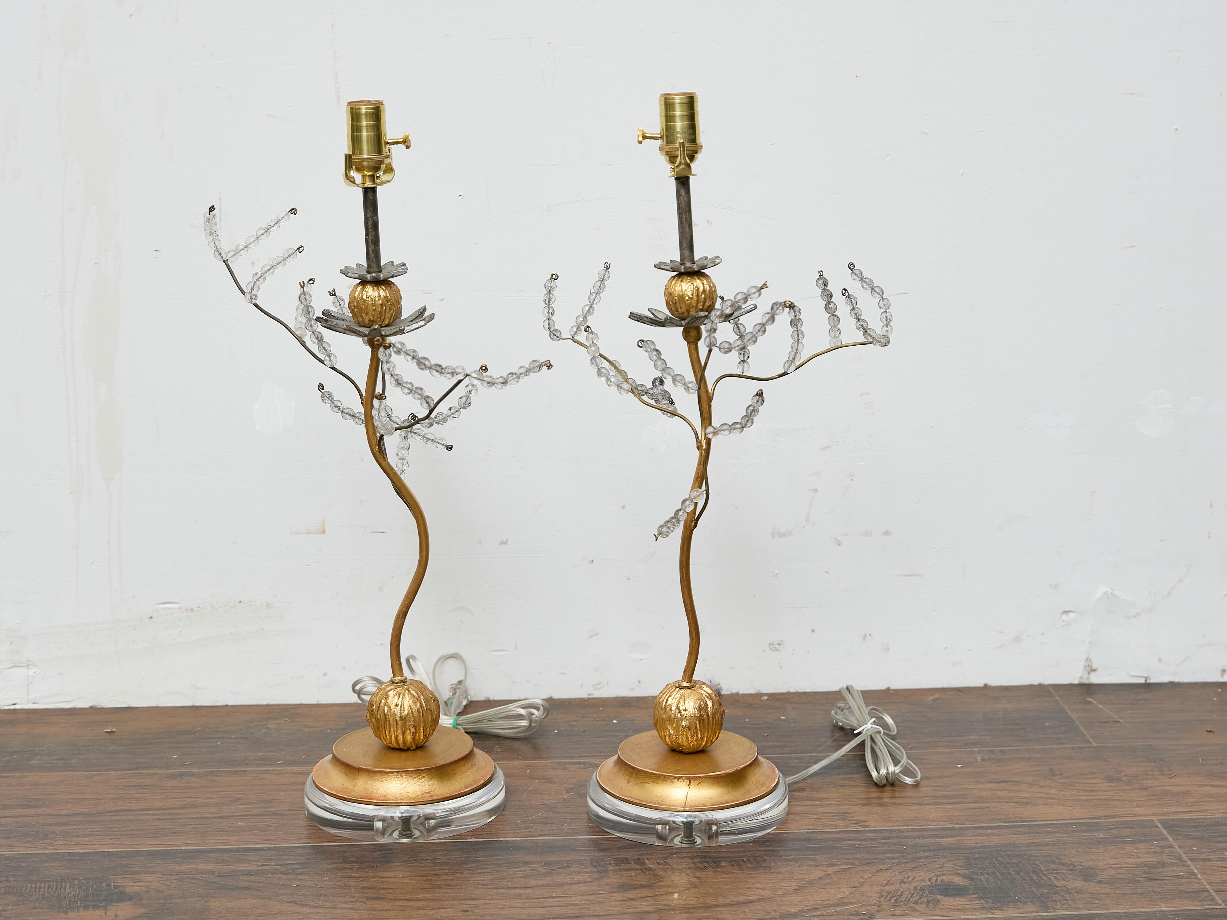 Una coppia di lampade da tavolo in metallo dorato in stile Baguès con fogliame in perline di cristallo, ricablate professionalmente per gli Stati Uniti e montate su basi in lucite personalizzate. Questa stravagante coppia cattura l'eleganza organica