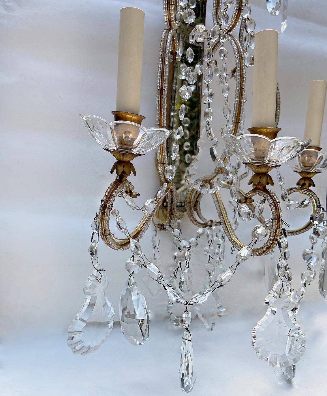 A pair of circa 1940's Italian gilt metal sconces with mirror back and crystal pendants.
Measurements:
Height: 24