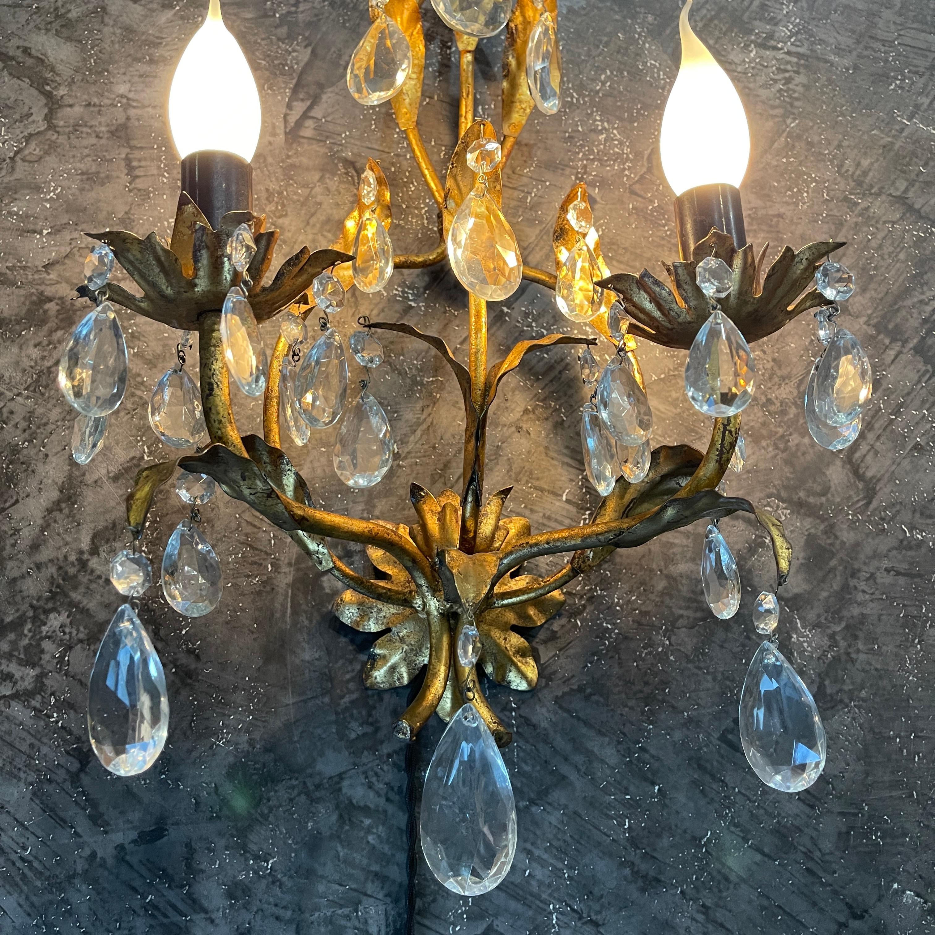 Enhance your space with the mesmerizing allure of this Pair of Gilt Metal Crystal Wall Sconces. Crafted with meticulous precision, these sconces exude opulence and sophistication. Crafted from gleaming gilt metal, feature intricate details and a