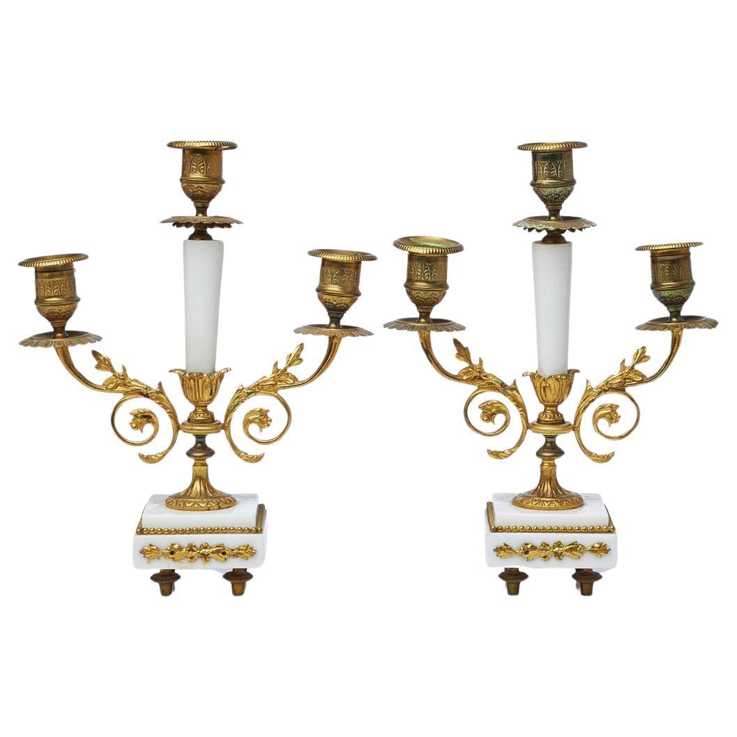 A Pair of Louis XVI 19th Century Gilt-Bronze and Gilt-Metal and Marble Candelabra Art Deco-style candlesticks and candelabra pressed cast and chased. Circular, curved feet with hinged. Tested with the scratch test, height approx. 27 cm, 22