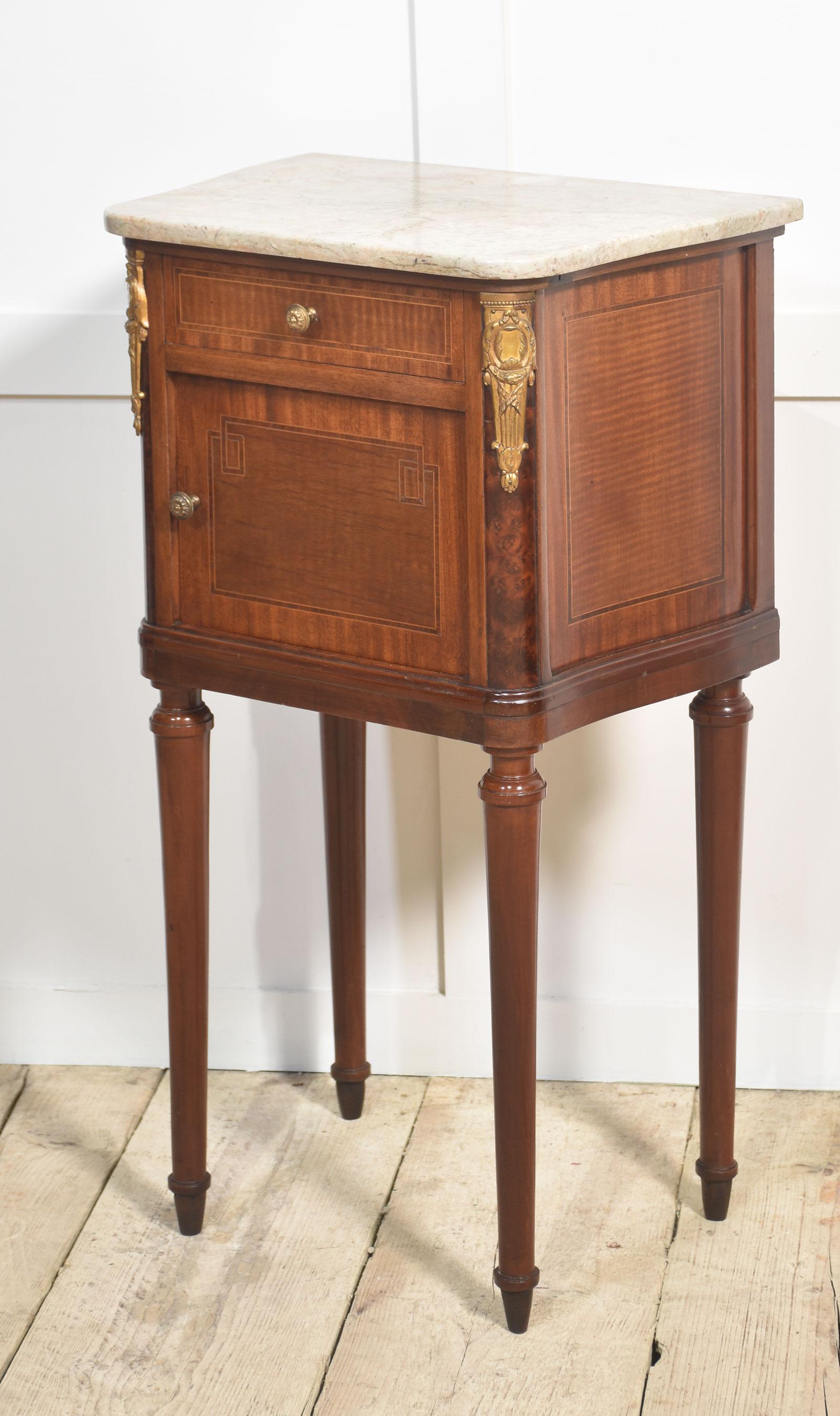 Pair of French Neoclassical gilt metal mounted bedside cabinets with shaped marble tops, above short drawer one fitted with cupboard door the other having an open shelf. All raised up on turned tapering legs.
Dimensions
Height 32.5 Inches
Width 18