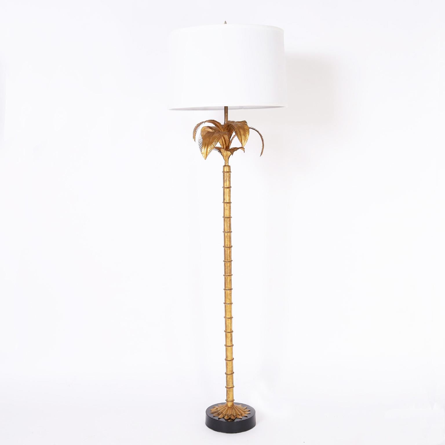 Chic pair of vintage Italian floor lamps crafted in gilt metal in a stylized palm tree form on black lacquer metal bases.