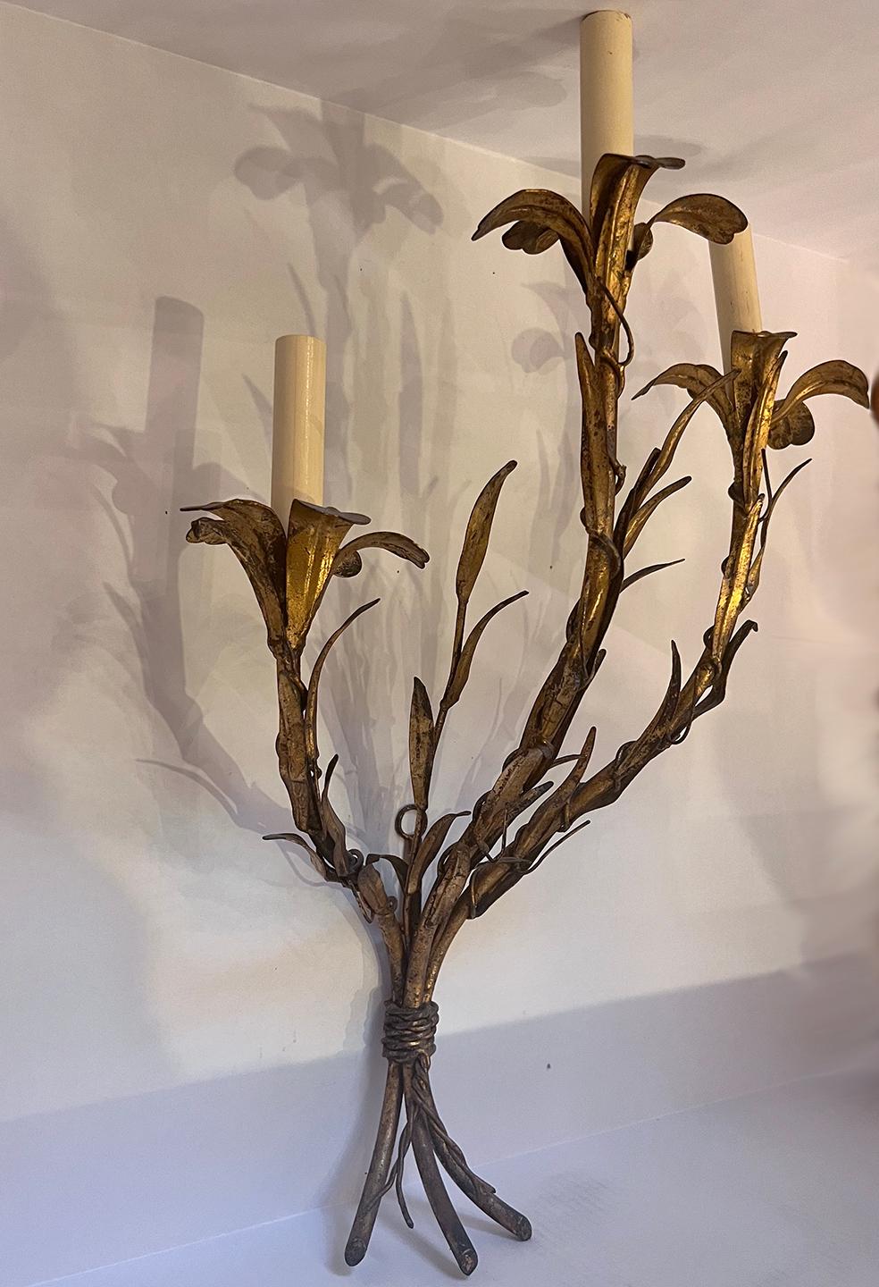 A pair of circa 1940's Italian gilt metal 3-light sconces in floral motif.

Measurements:
Height: 19.5
