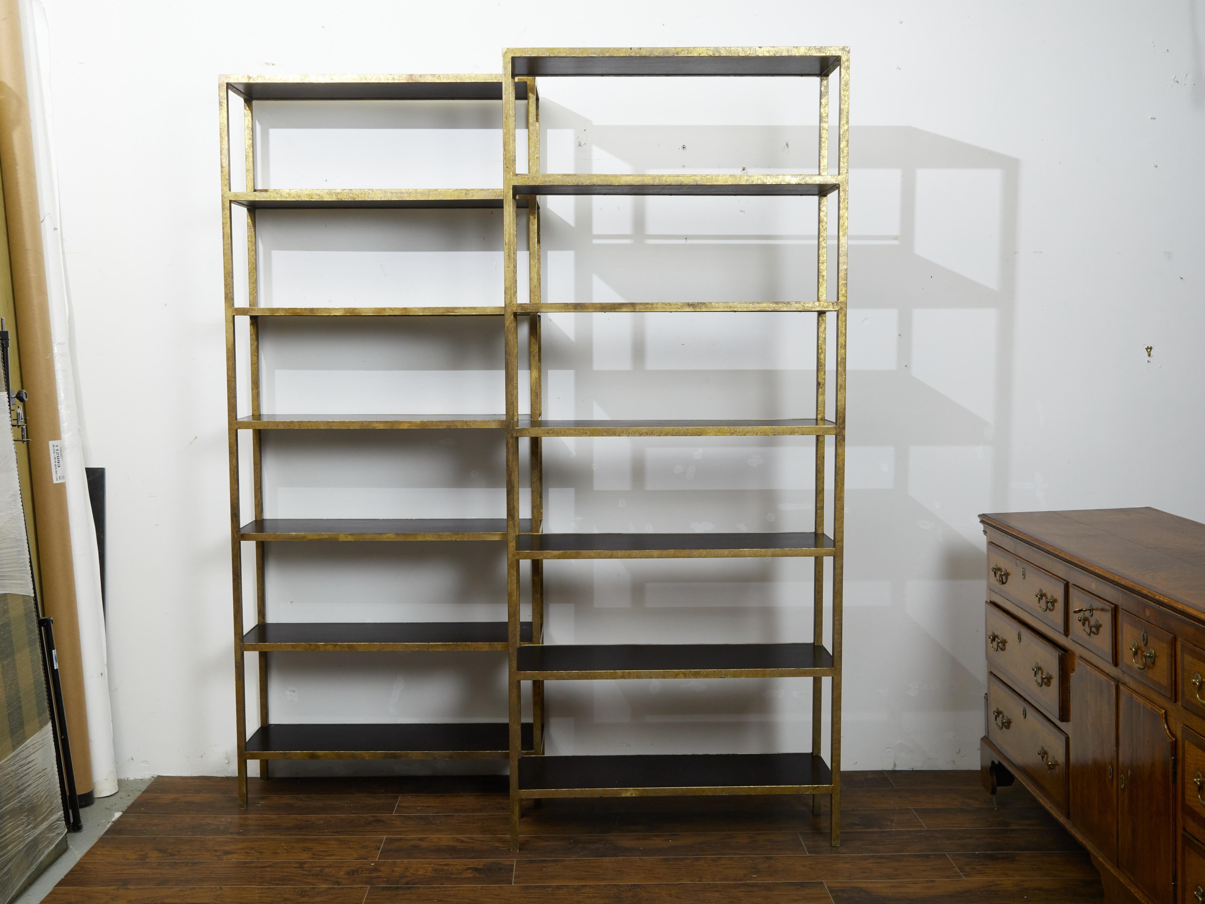 A pair of vintage gilt metal shelves from mid 20th century, with ebonized wood. Created during the midcentury period, each of this pair of shelves features a gilt metal structure perfectly contrasted by ebonized wooden shelves. With their linear