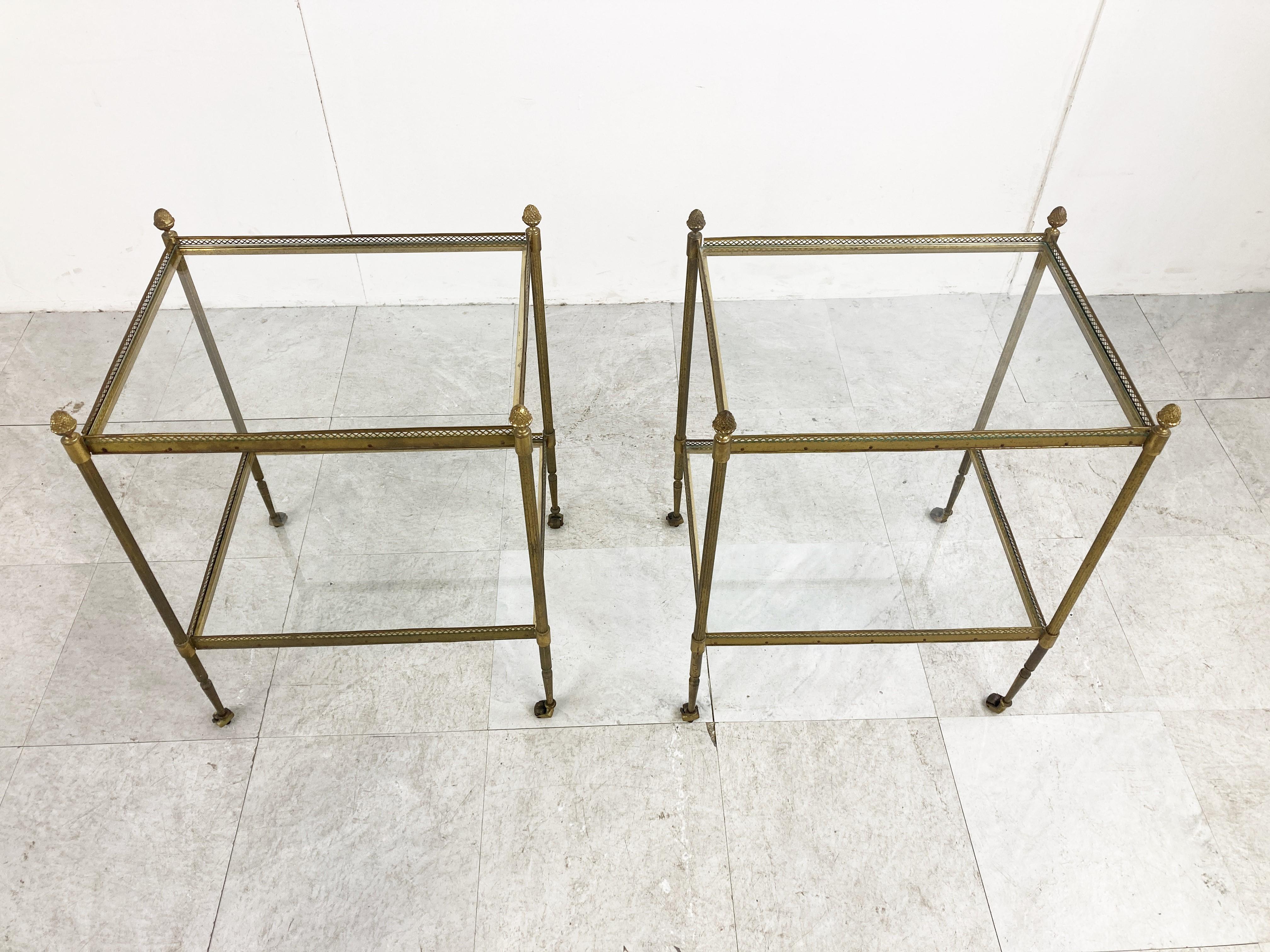 Mid century gilt metal acorn side tables by Maison Jansen. 

The side tables have small caster (wheels) so they are easy to move about.

Very nicely patinated gilt metal frames with clear glass tops.

Very detailed acorn finials

1960s -