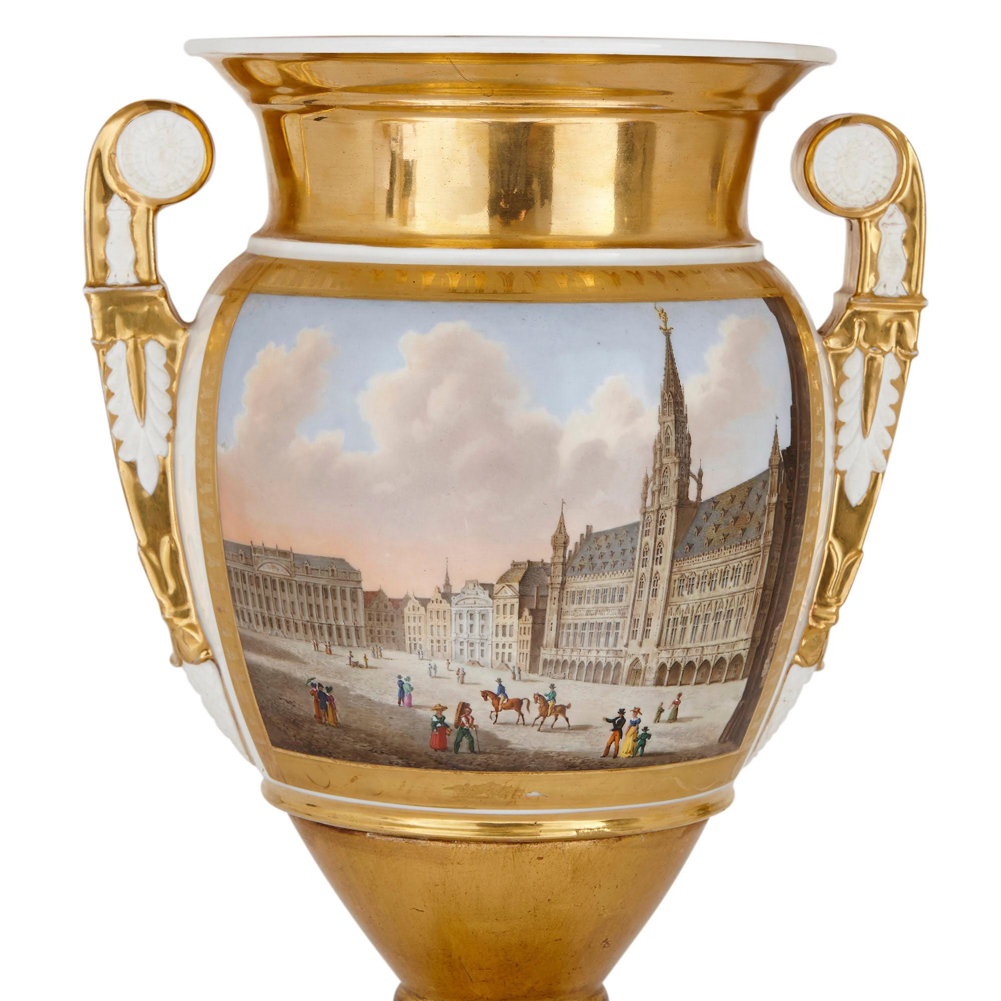 This pair of Paris porcelain vases feature finely painted urban scenes: a depiction of Amsterdam on one vase and a view of Brussels on the other. The Amsterdam vase portrays a view of Dam Square and is inscribed beneath, within the encompassing gilt