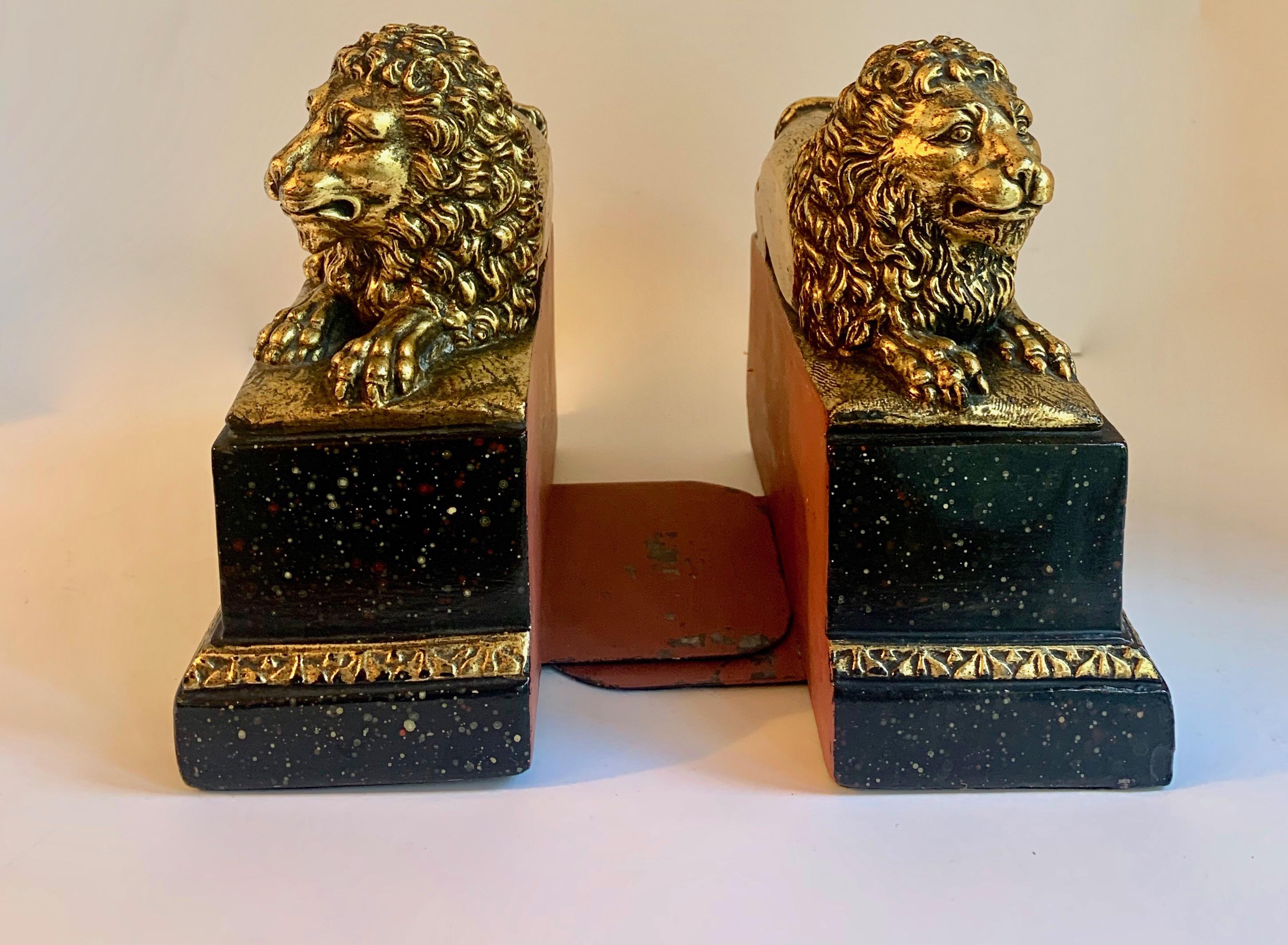 Patinated Pair of Gilt Reclining Lions on Black Stands