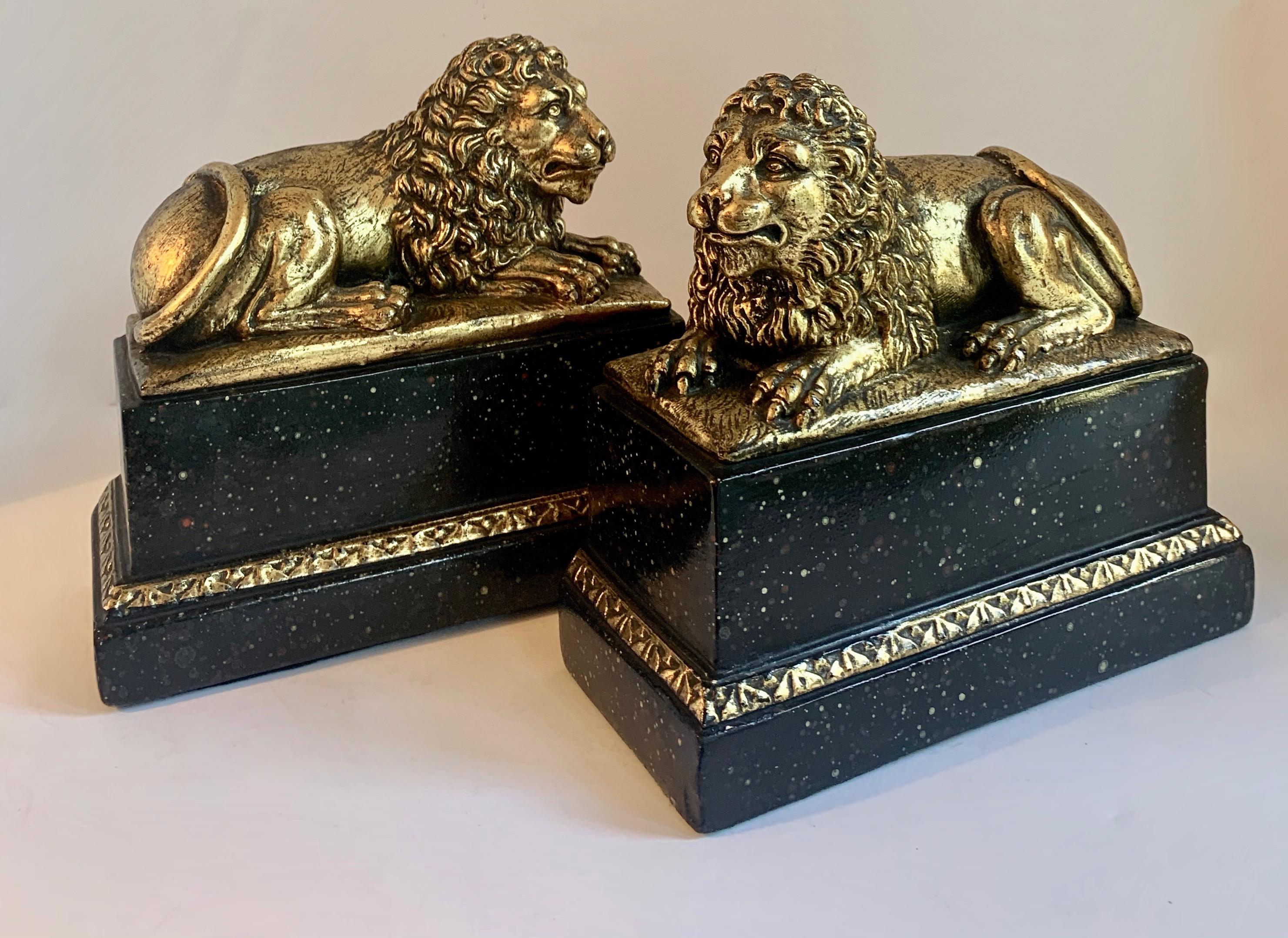 Pair of Gilt Reclining Lions on Black Stands In Good Condition In Los Angeles, CA