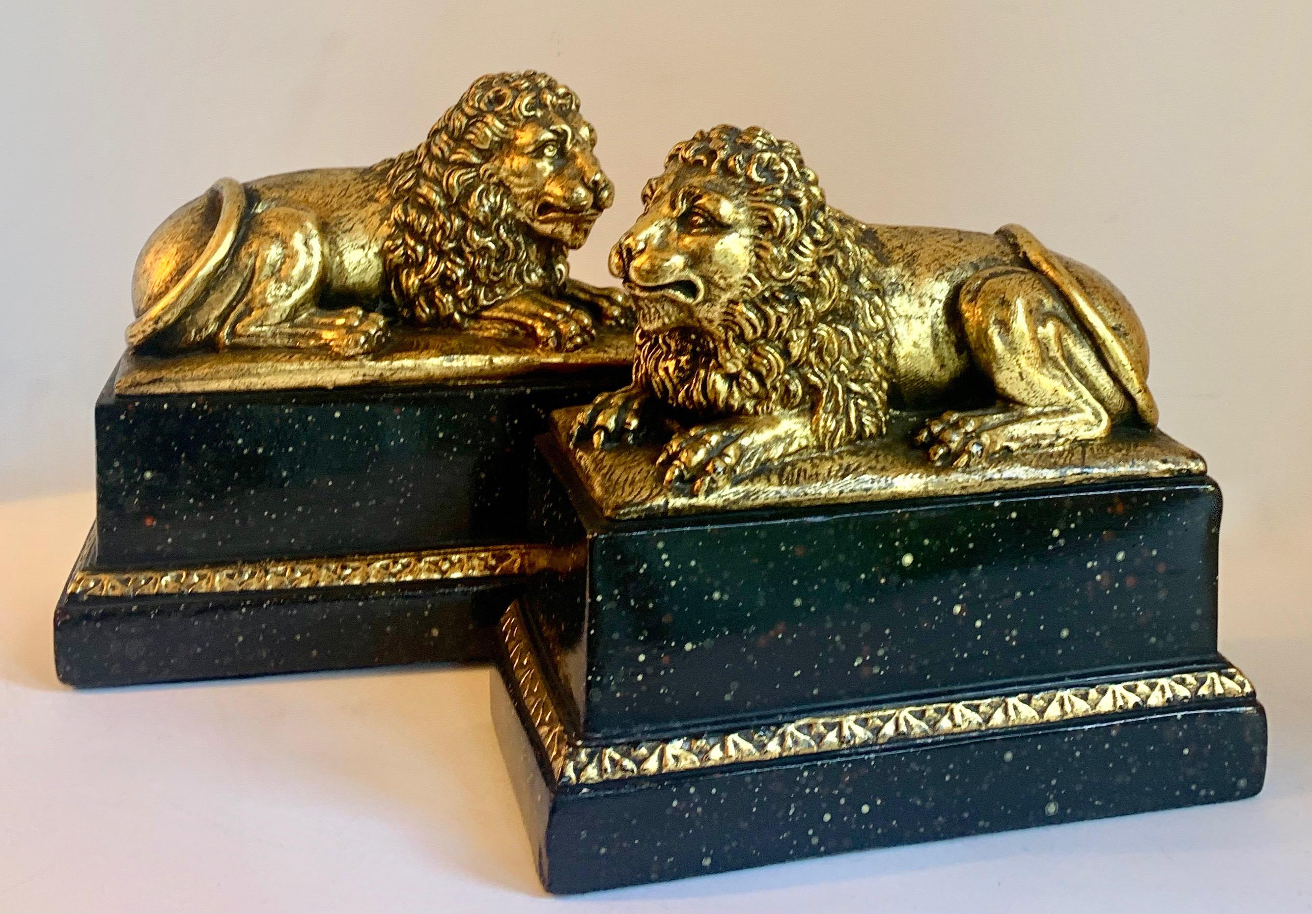 20th Century Pair of Gilt Reclining Lions on Black Stands