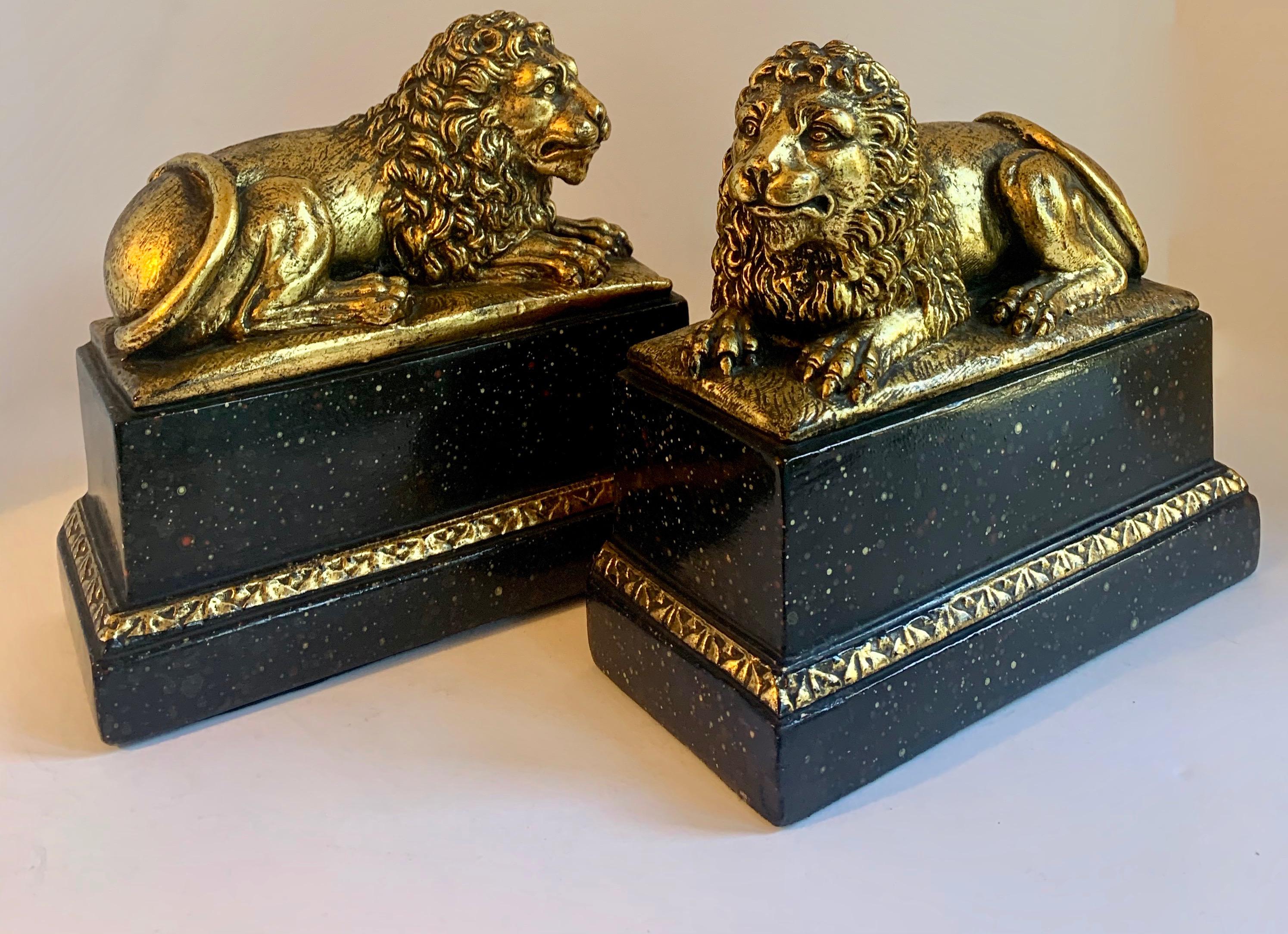 Gold Pair of Gilt Reclining Lions on Black Stands