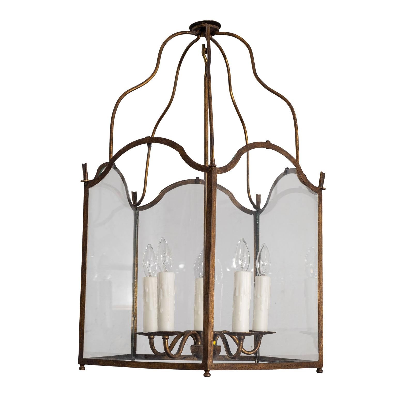 Pair of gilt-tole five-sided Italian lanterns with glazed panels (glass), circa 1910-1930. Newly wired for use within the USA using UL listed parts. Five candelabra-size sockets in each lantern. Include chain and canopies (listed height doesn't