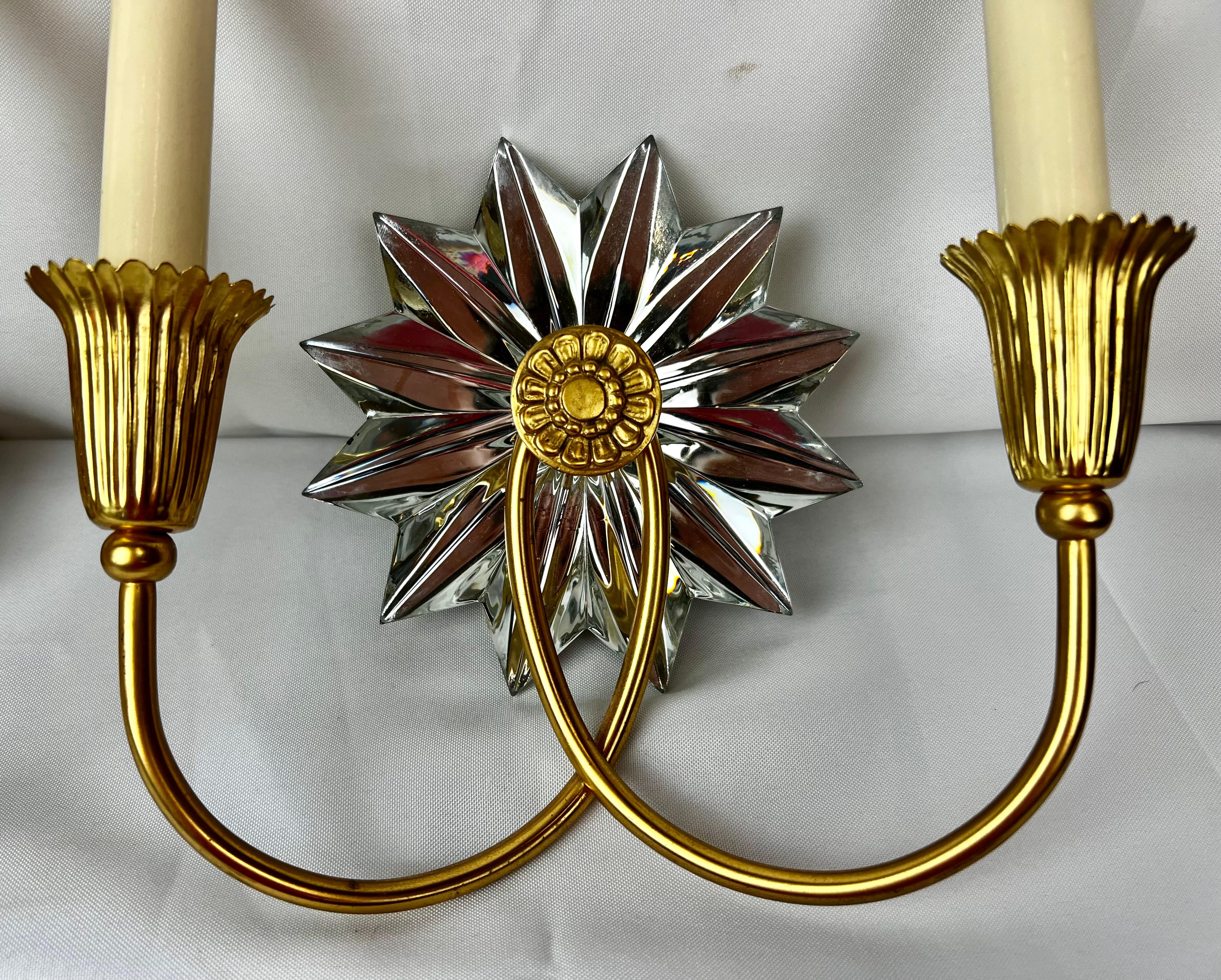 Pair of gilt two light sconces each with a mirrored 12 point starburst. The gilt finish and mirrored appointments give them a stand alone appeal that can mix with modern or traditional.
They are in nearly new condition.
H-10.25