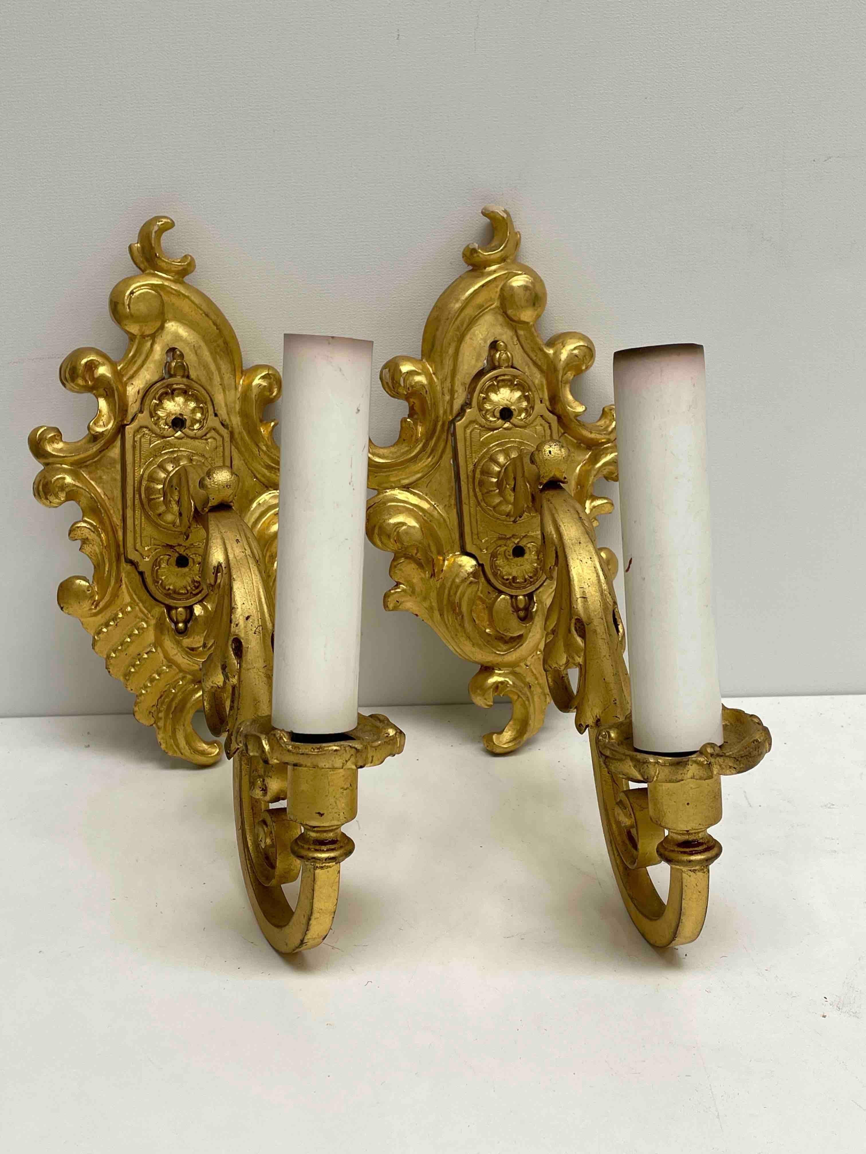Add a touch of opulence to your home with this charming pair of sconces. Perfect gilt wood and gilt metal to enhance any chic or eclectic home. We'd love to see it hanging in an entryway as a charming welcome home. Built in the 1960s, in Italy,