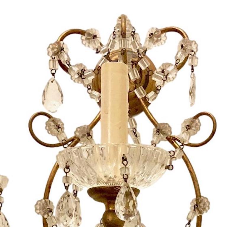 Paire d'appliques à 3 lumières en bois et métal doré, datant des années 1920, avec perles de verre et gouttes de cristal.

Mesures :
Hauteur : 19