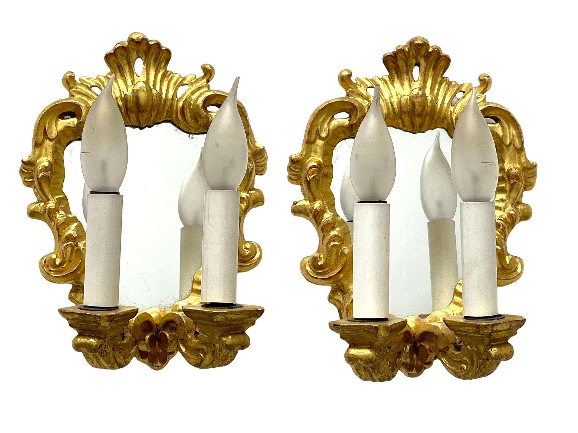 Add a touch of opulence to your home with this charming pair of sconces. Perfect gilt wood and a mirror to enhance any chic or eclectic home. We'd love to see it hanging in an entryway as a charming welcome home. Built in the 1960s, in Italy, these