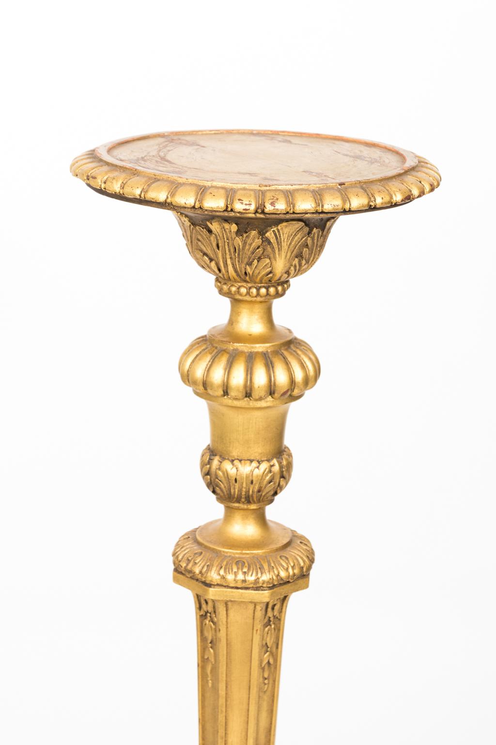 George III style stands in giltwood, circa late 19th century. The stands are carved with acanthus leaves, gadroon trim, and detailed lion's paw feet. Please note that there is wear consistent with age especially on the top where there is a