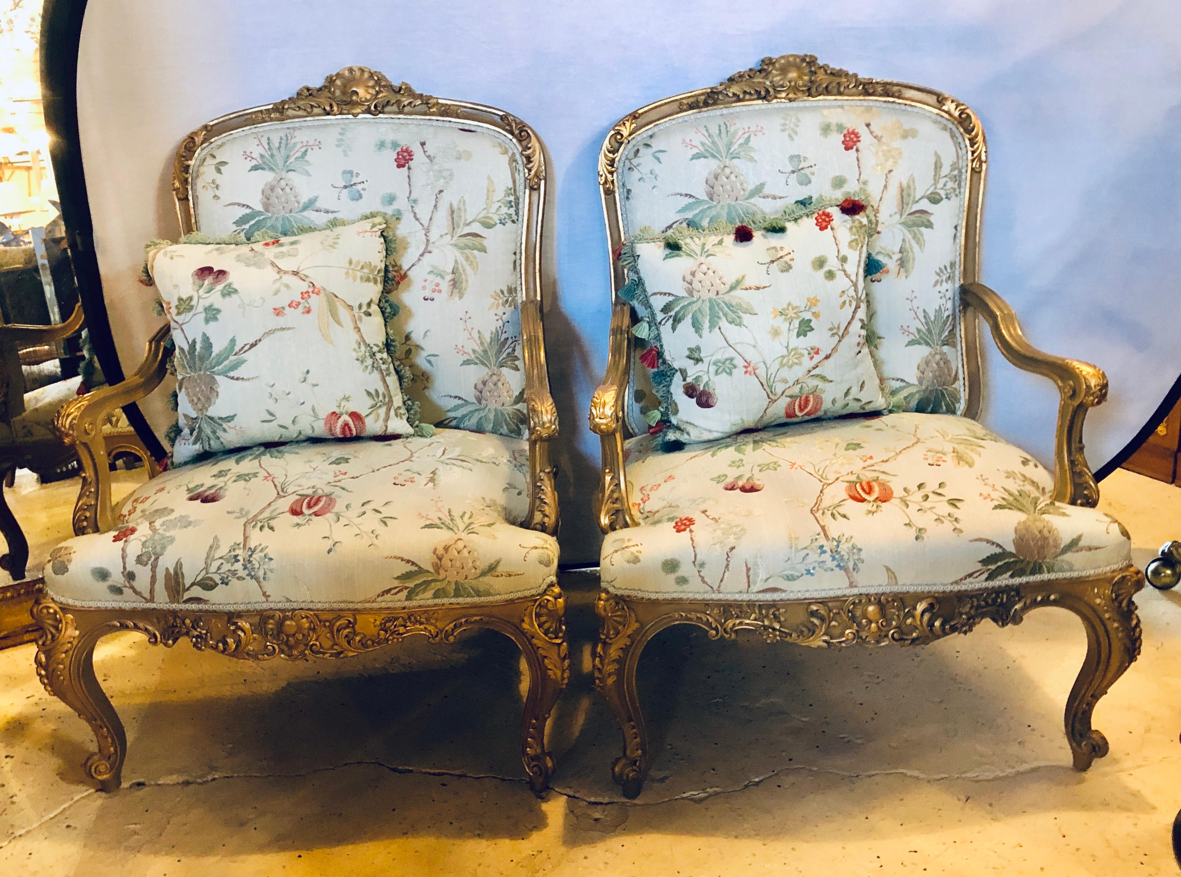 Pair of gilt wood Louis XV style overstuffed fauteuils in scalamandre fabric. In a word, spectacular. These wonderfully carved gilt wood frames in a light paint decorated background are finely carved and covered in a great Scalamandre fabric. Each